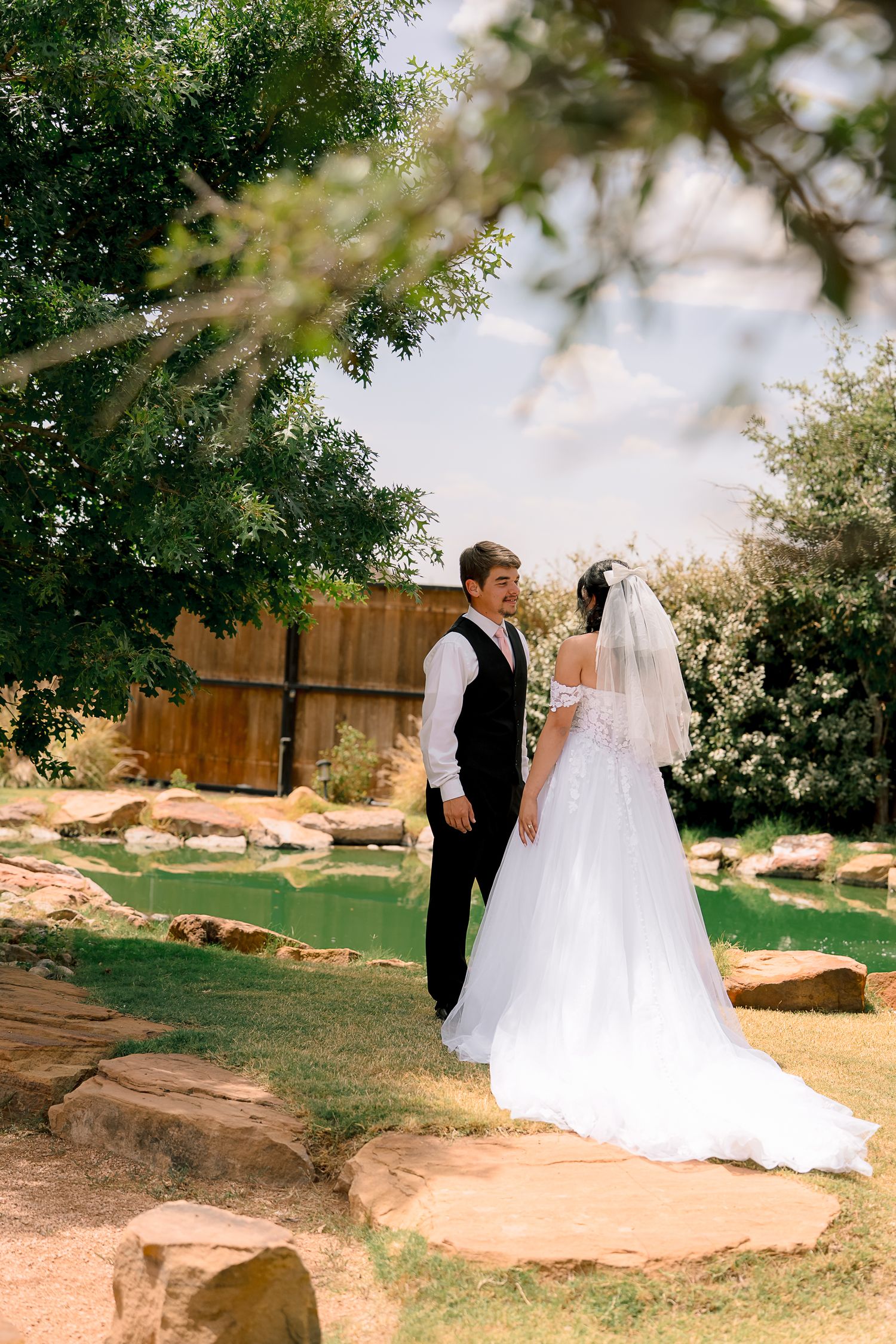 Bride and groom sharing a romantic first look moment in a lush garden setting.
