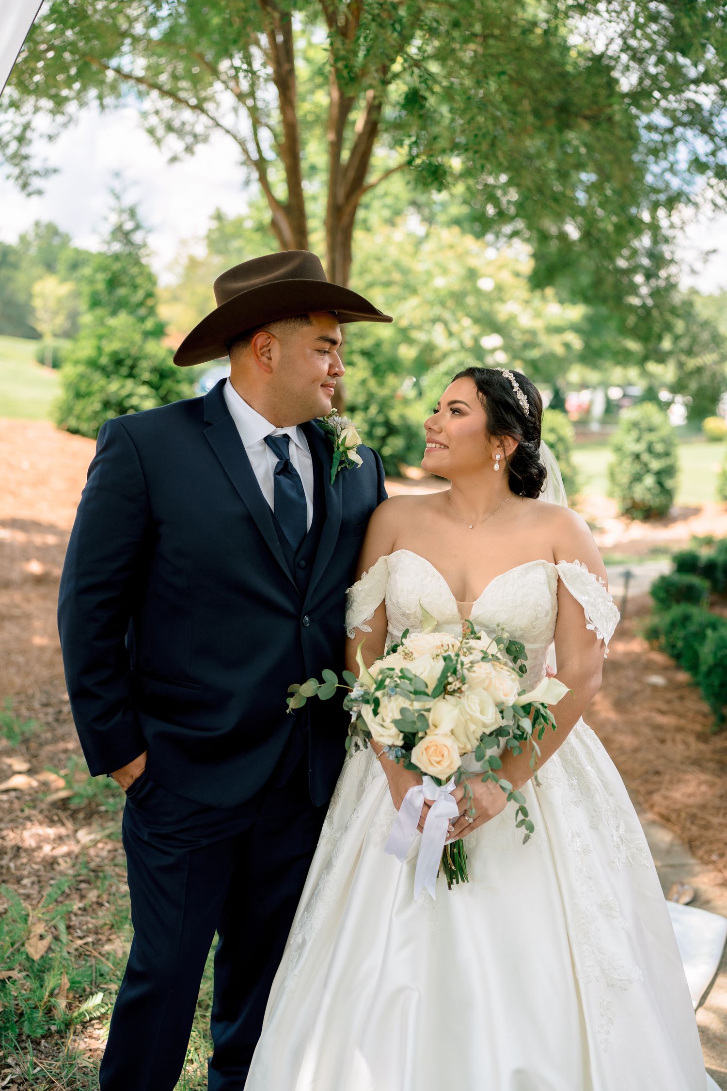 A romantic outdoor wedding scene features a couple in formal attire against a natural garden backdrop.