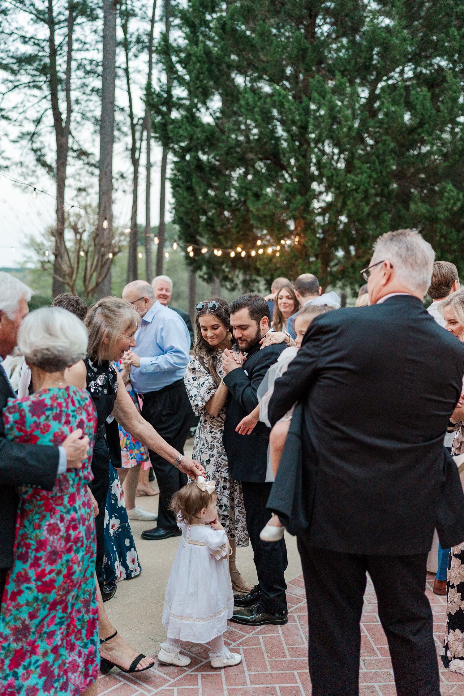 Wedding guests dancing and celebrating at an outdoor reception.