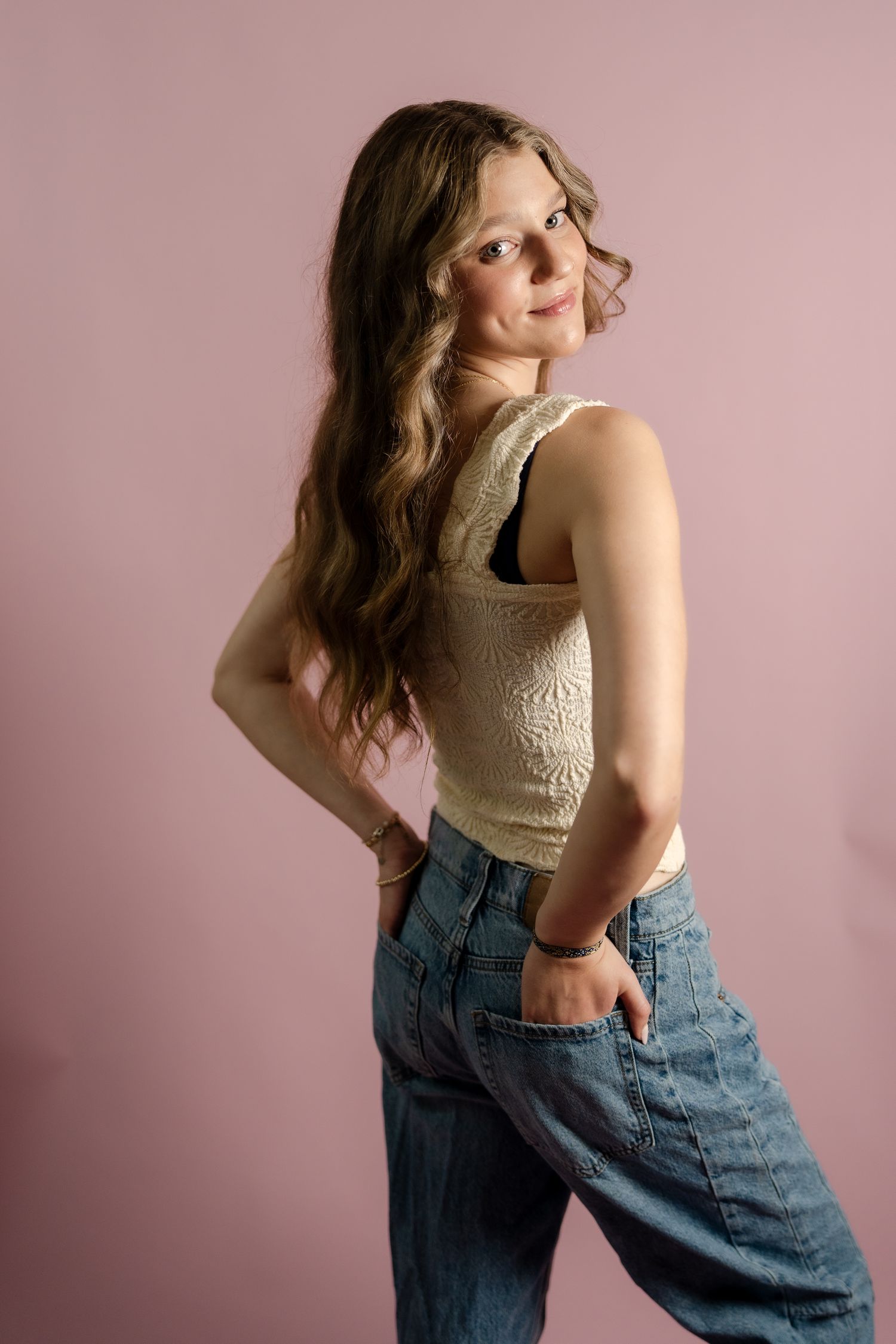 Side view portrait showing casual summer style with textured tank top and relaxed denim.