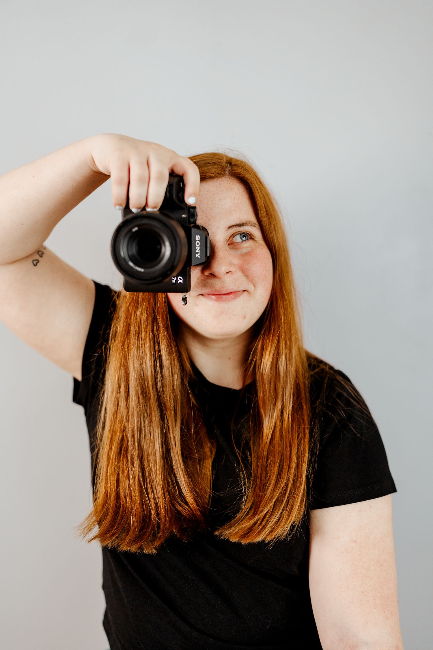 Person with long hair demonstrates different camera angles and poses against light background.