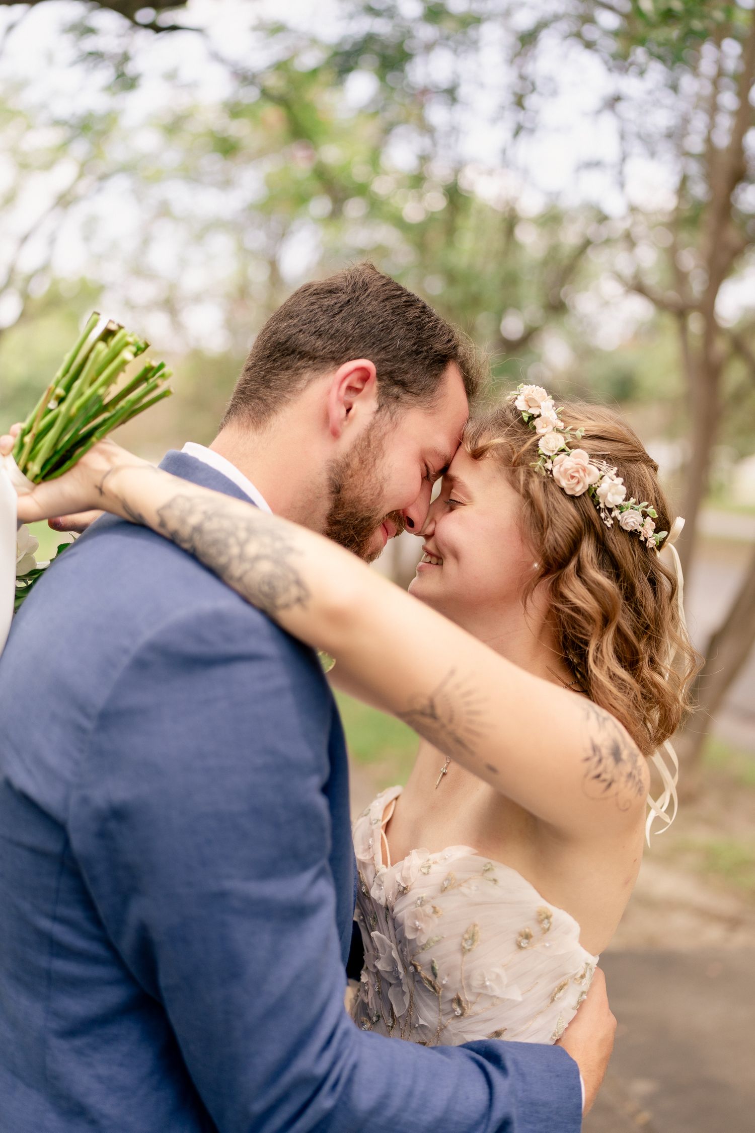 Newlyweds share intimate moments during their first look photos in an outdoor garden setting.