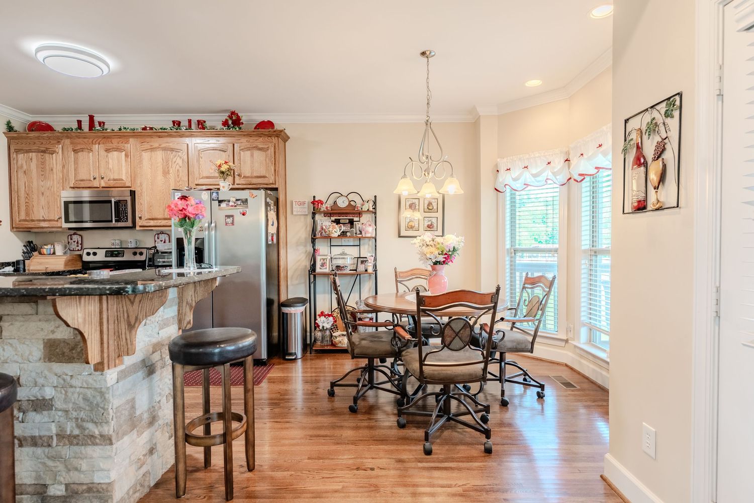 Modern office space with white walls, hardwood floors, and natural light streaming through large windows.