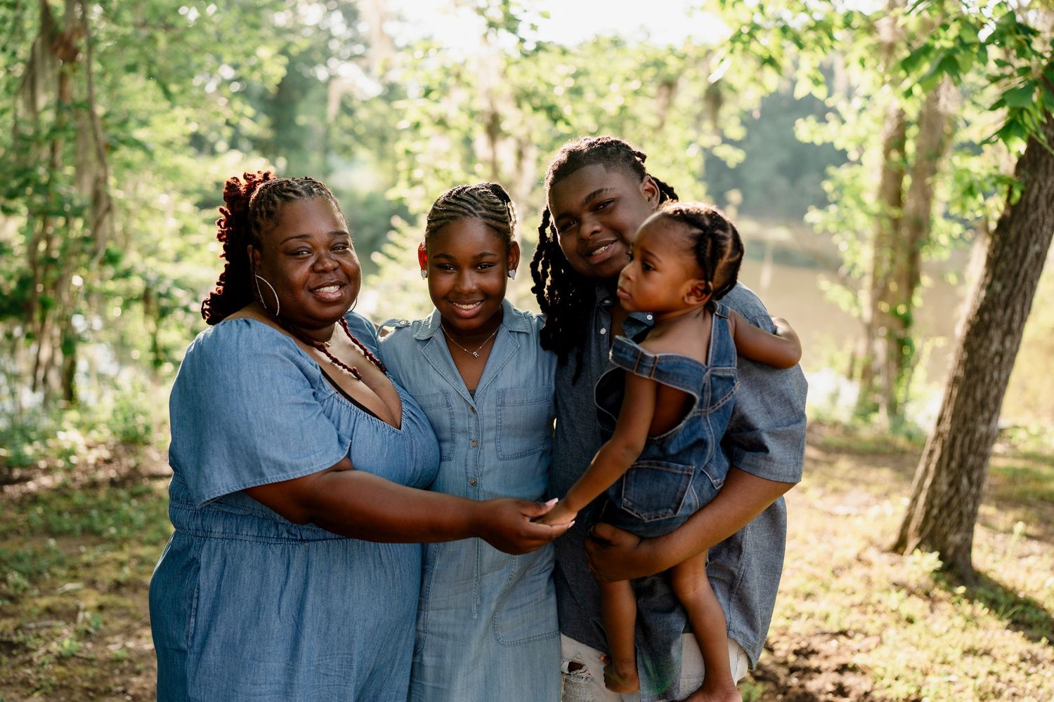 Family shares loving moments in coordinated blue clothing during an outdoor photoshoot.