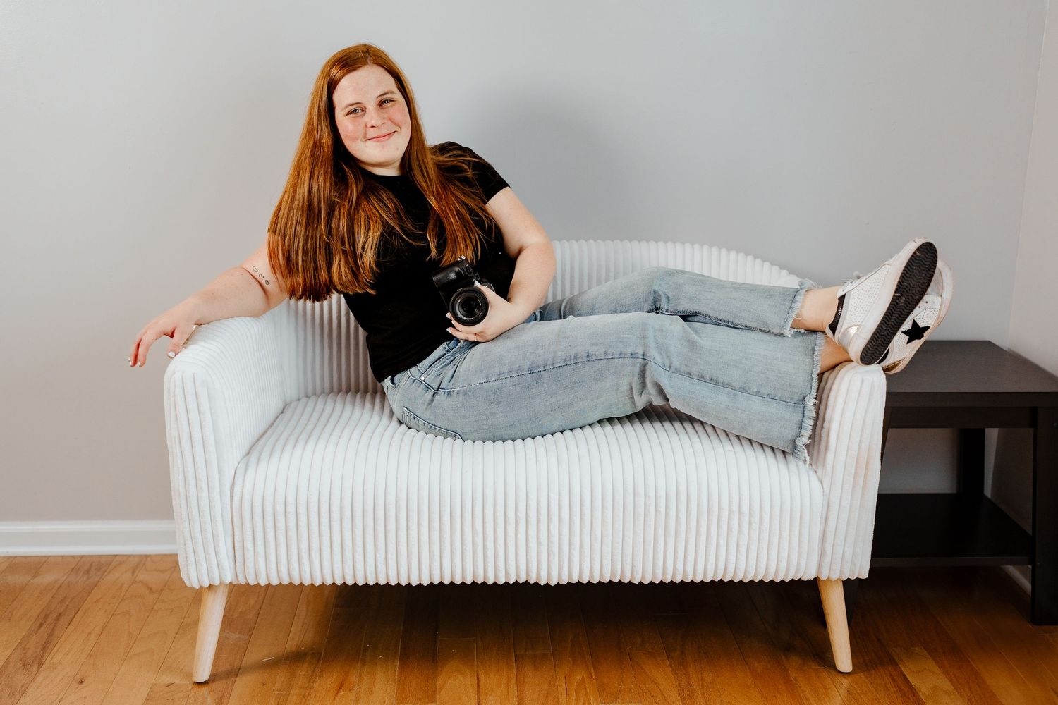 Creative portrait session showing different poses on white modern sofa against grey wall.