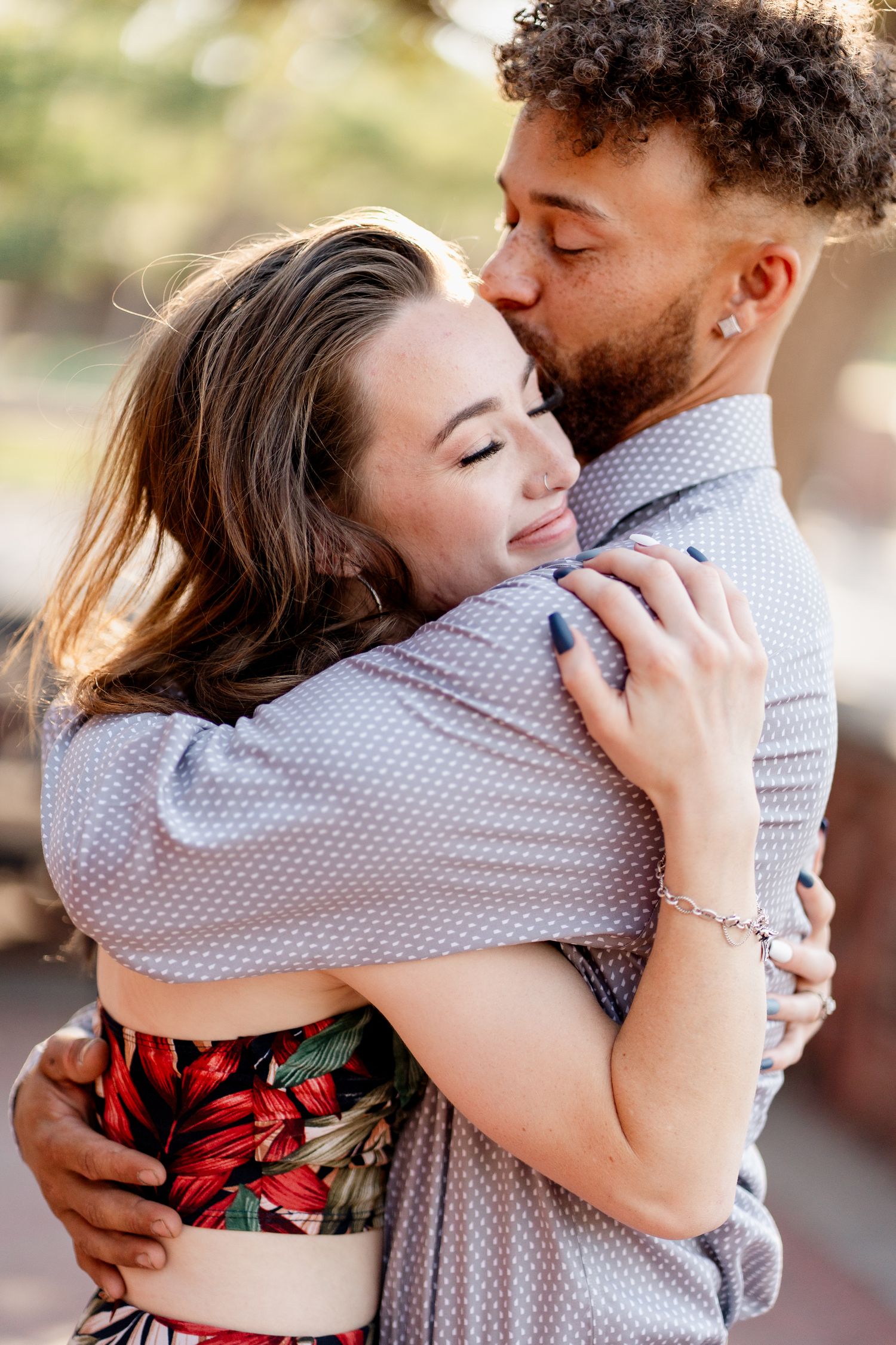 A tender embrace between a couple during their romantic outdoor photo session.