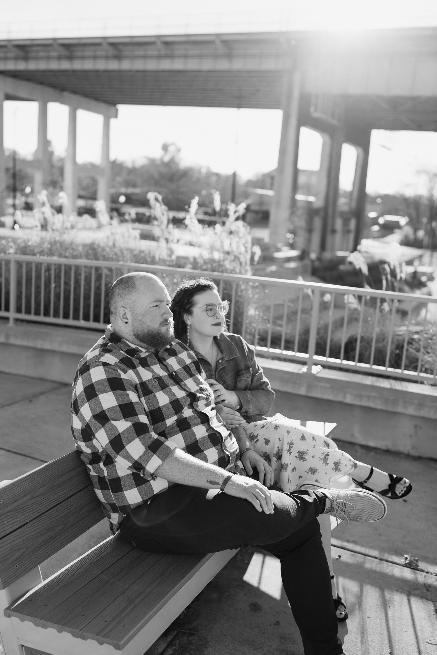 A playful couple in casual attire posing on a wooden deck during a photo session.