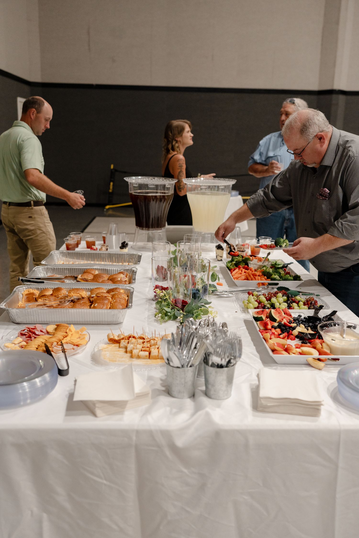 Long buffet table with appetizers and refreshments set up for a catered event.