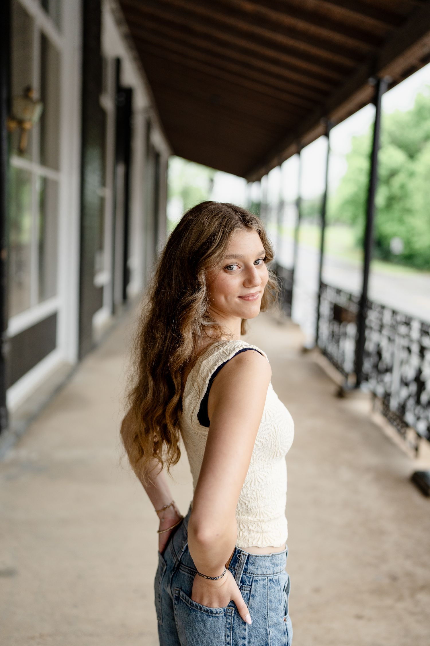 Portrait session in a covered walkway with elegant white columns and natural light.