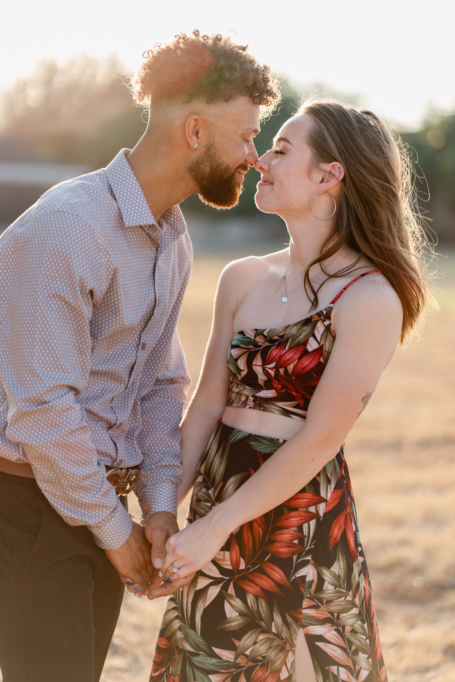 A couple shares intimate moments during golden hour photography session outdoors.