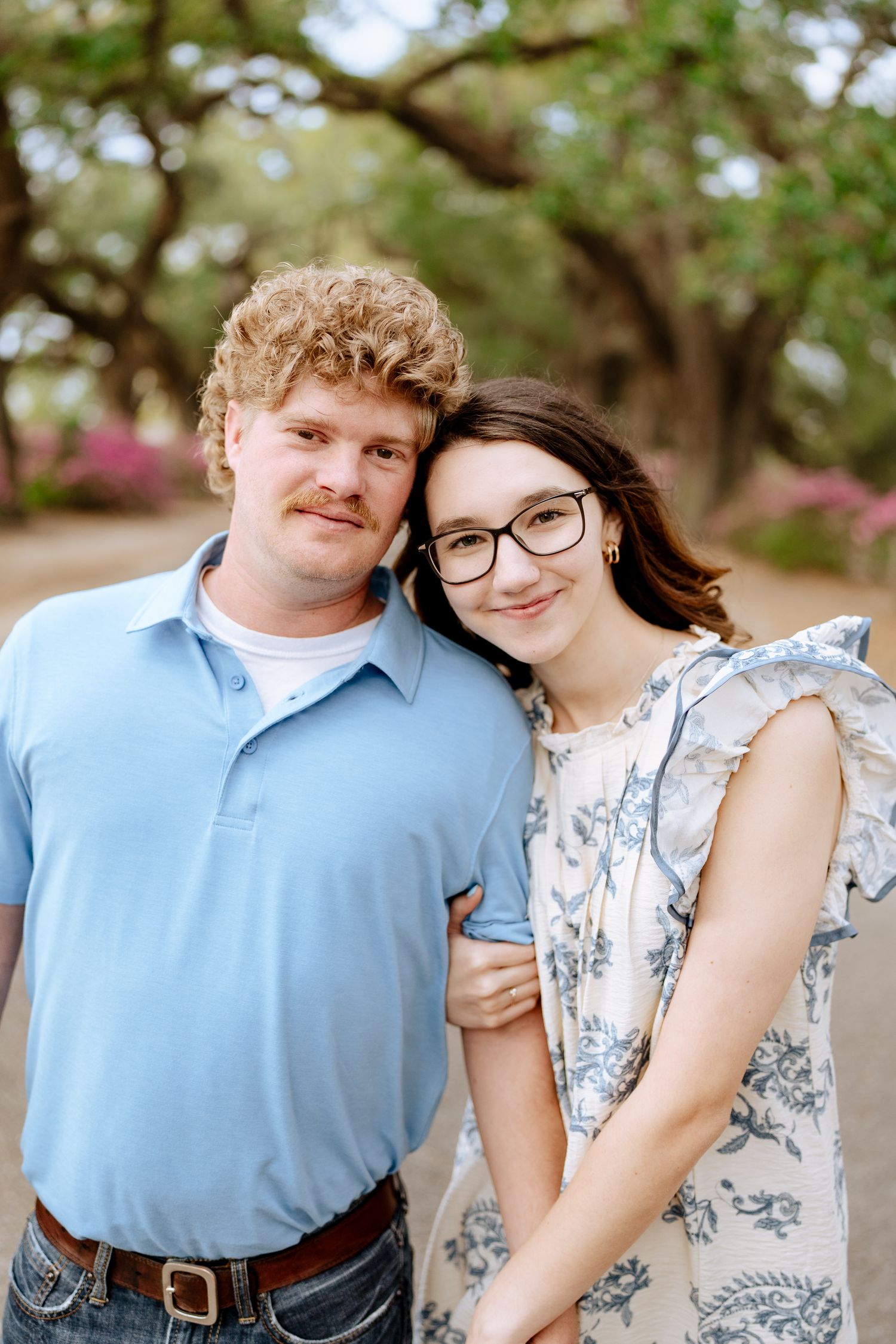 A couple poses outdoors in coordinated blue outfits during a romantic photoshoot.