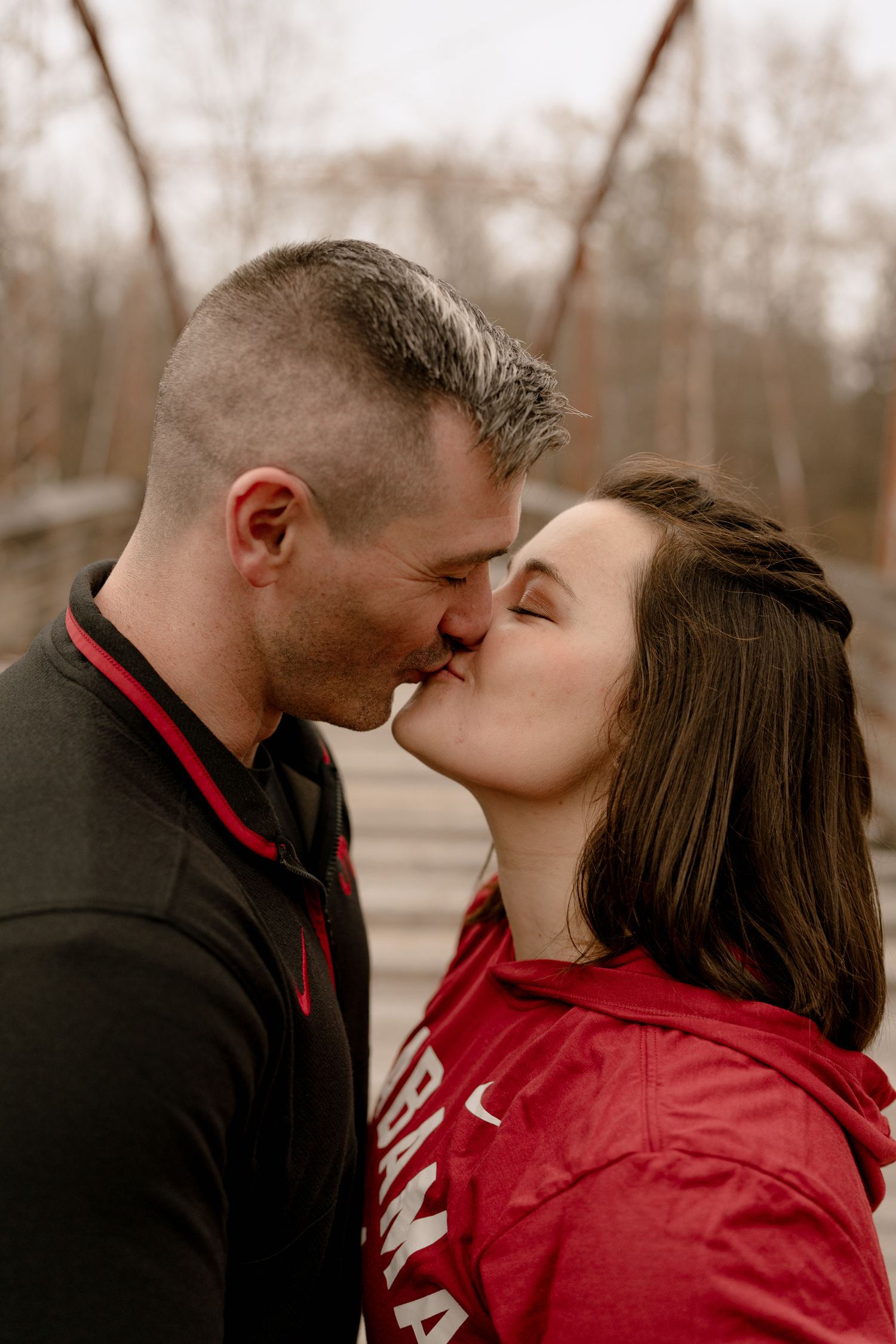 A romantic couple shares an intimate moment in a sepia-toned outdoor setting.