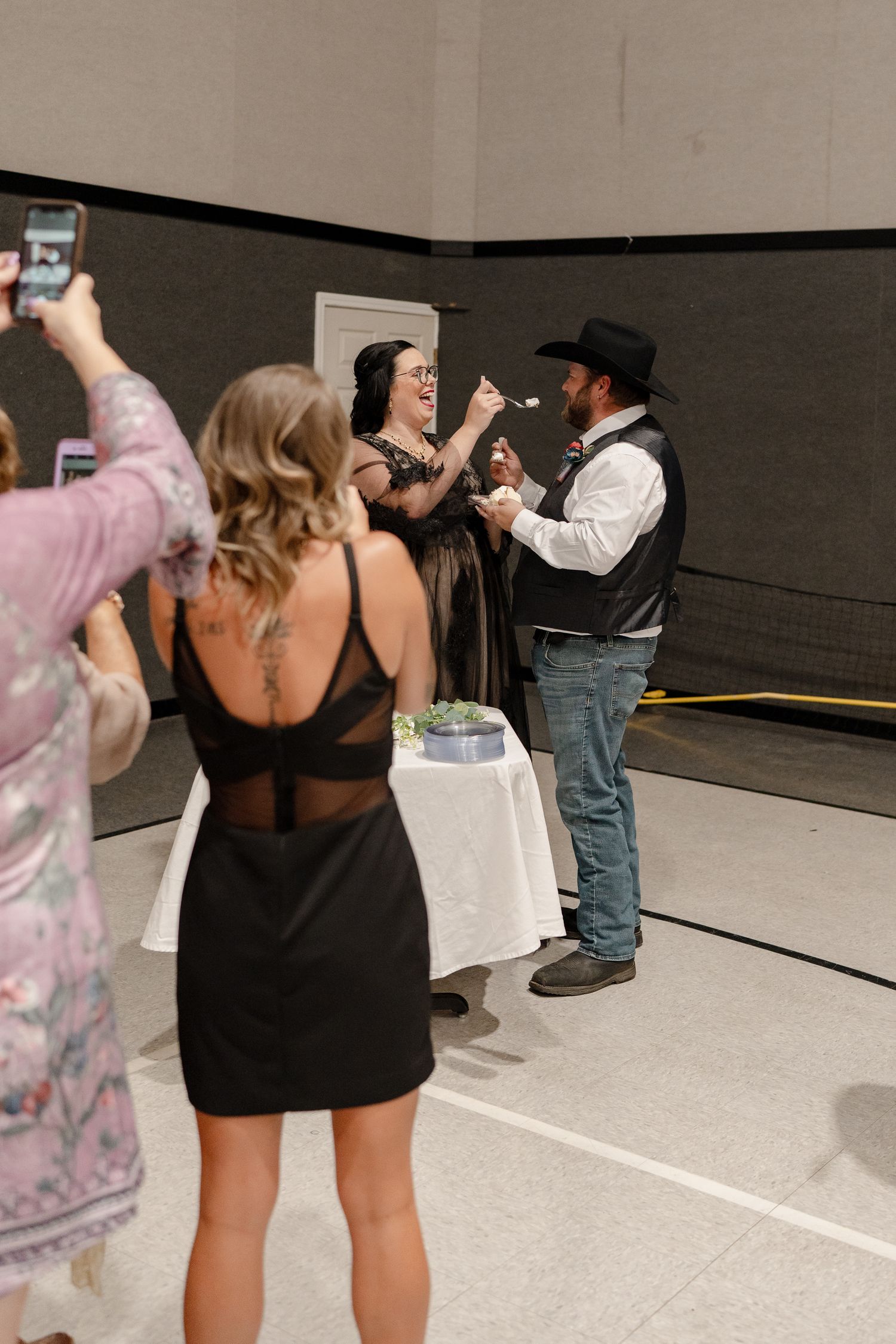 Students line up in a large indoor space with phones raised, appearing to be taking photos or videos.