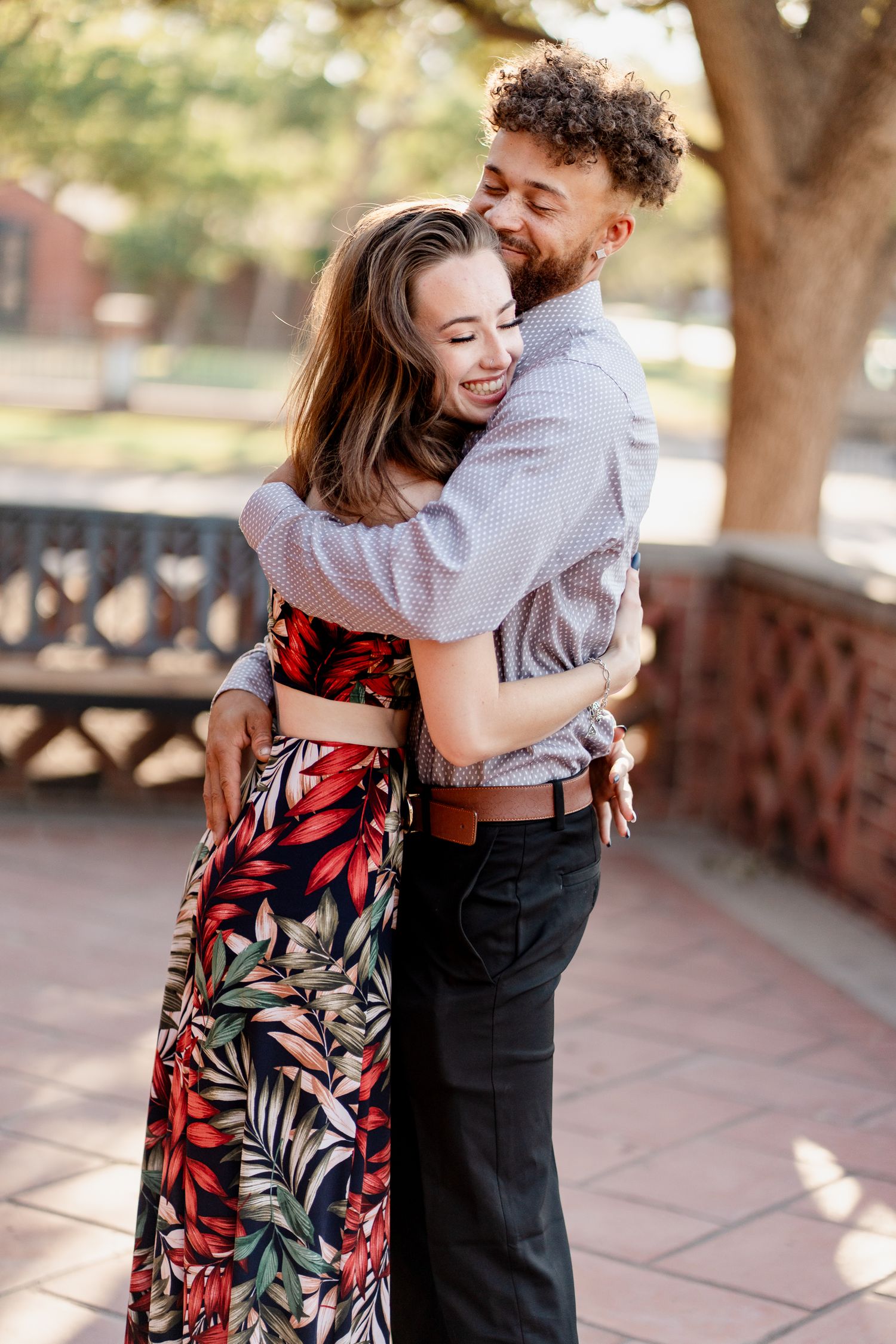 A romantic outdoor couple portrait session with the woman wearing a floral dress and man in business casual.