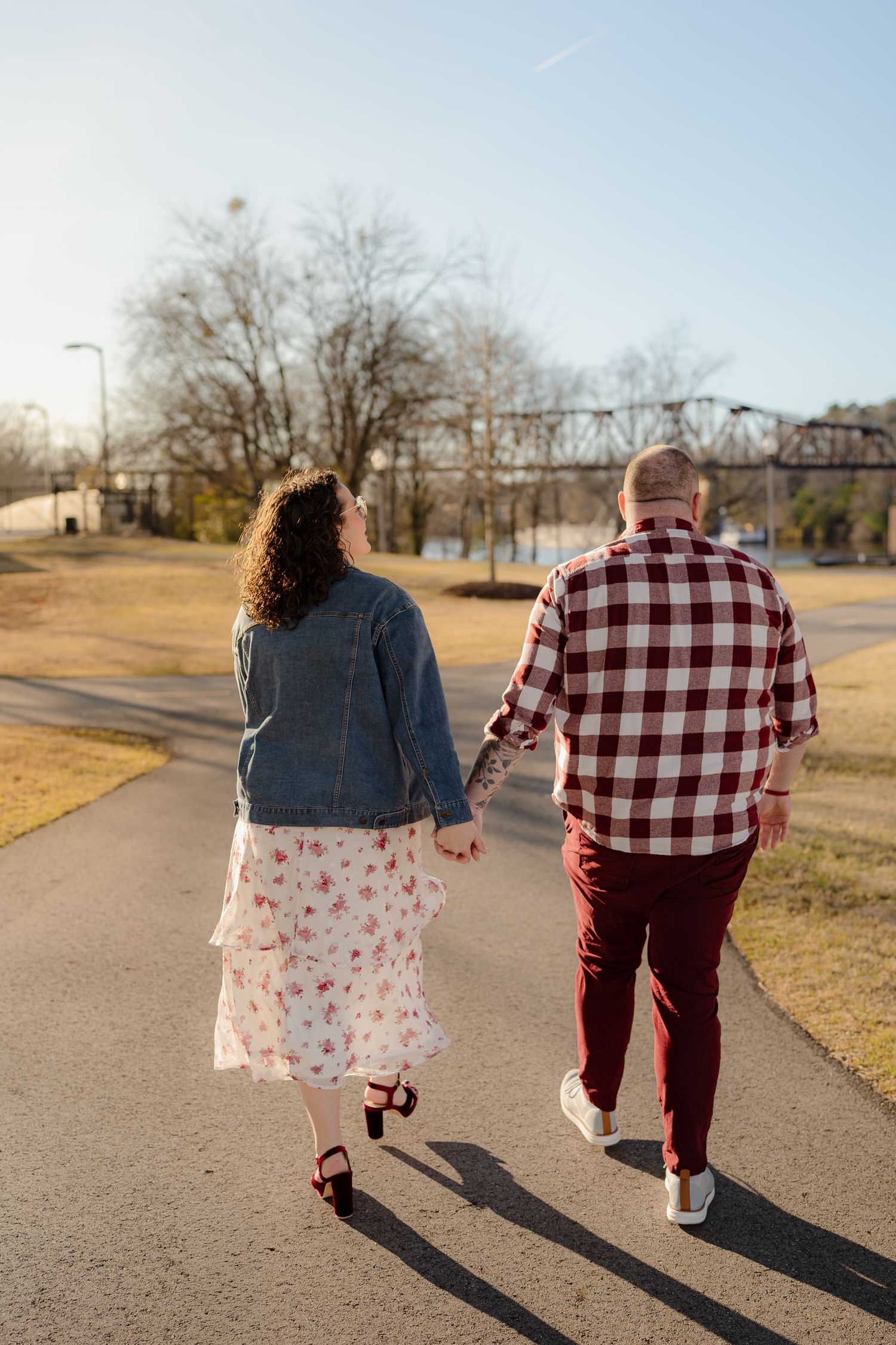 A couple walking together on a path wearing coordinating red and white outfits on a sunny day.