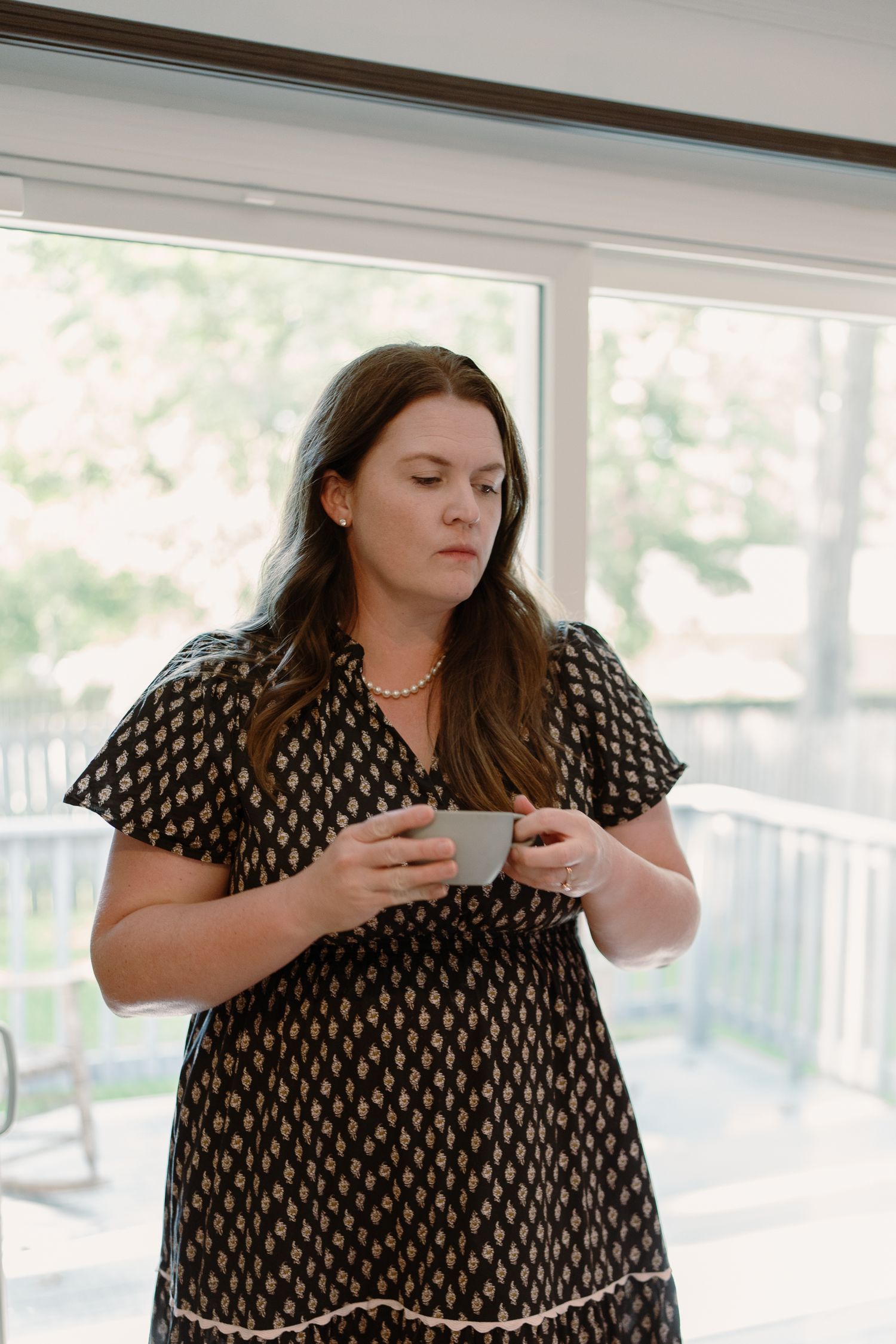 Woman in black patterned dress sitting on couch looking at phone in series of connected images.