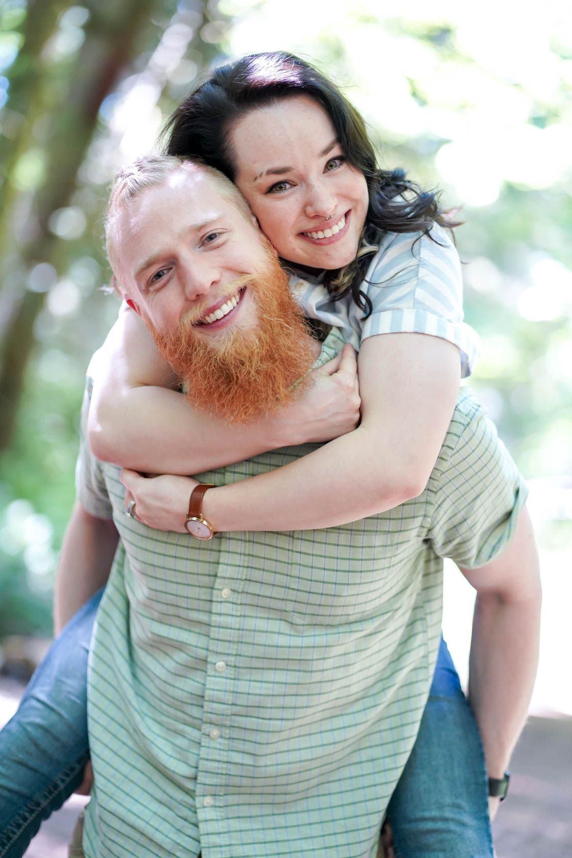 A joyful piggyback ride captured on a sunny forest trail.