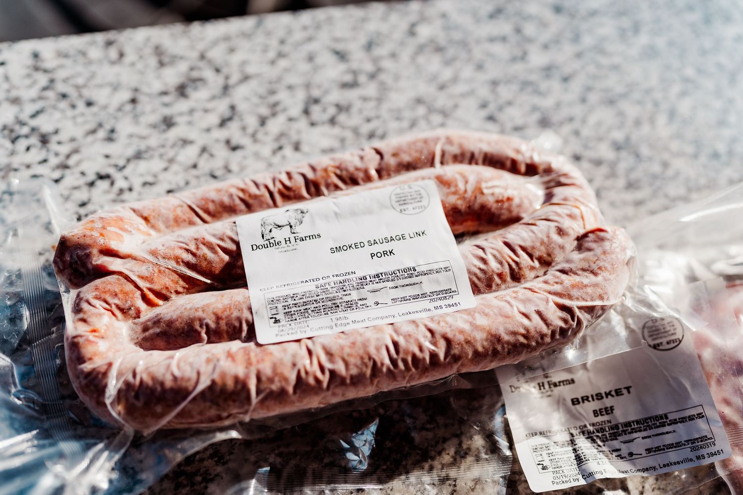Close-up view of packaged meat with labels on a counter surface.