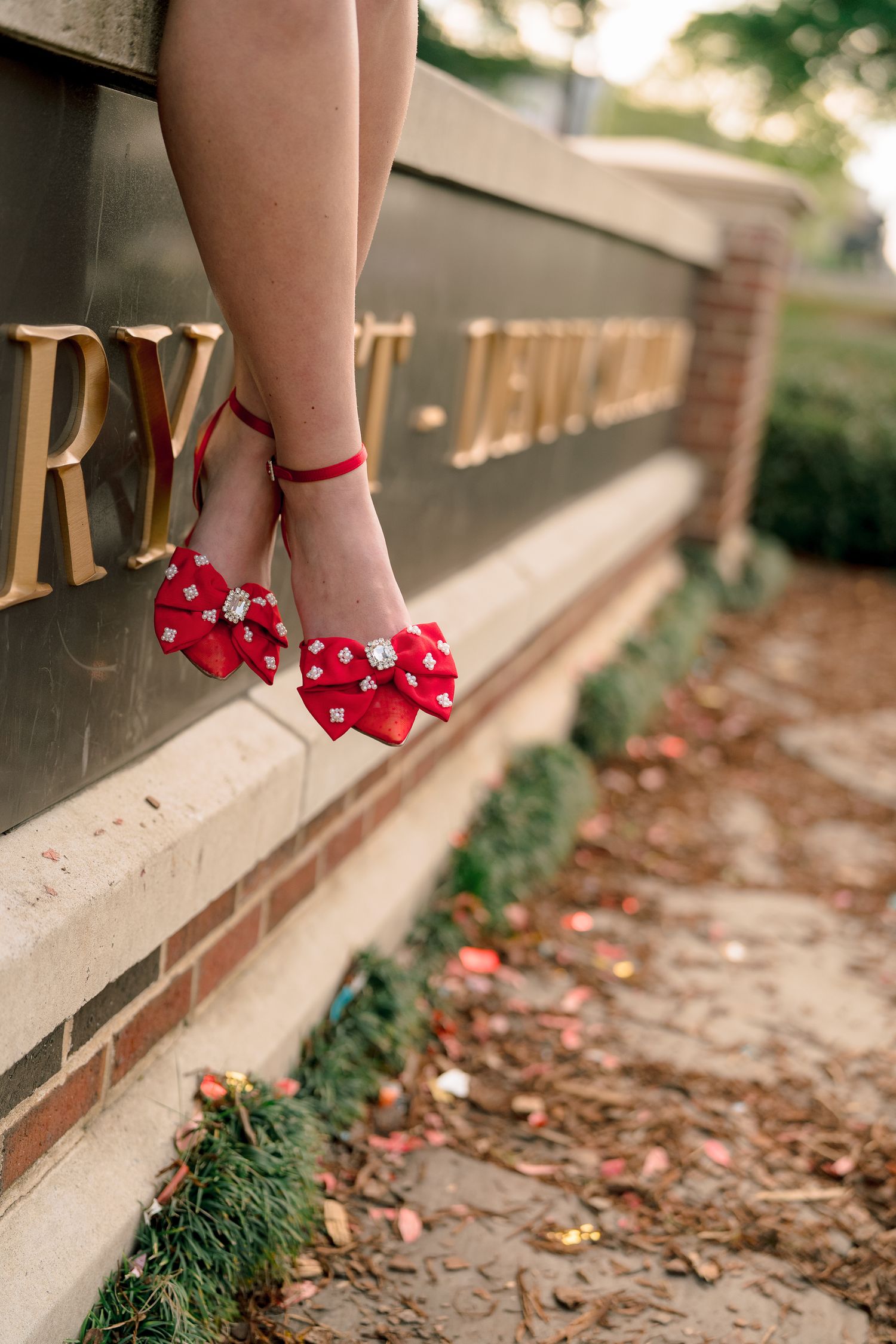 Close-up shots of red bow shoes against a brick wall and fallen leaves.
