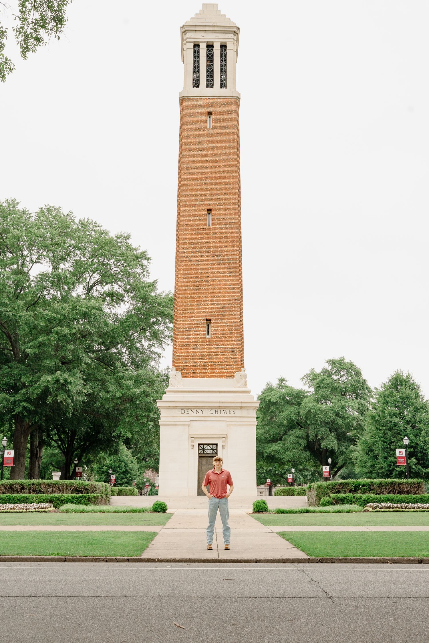 Tall brick bell tower with white accents stands prominently on a university campus.