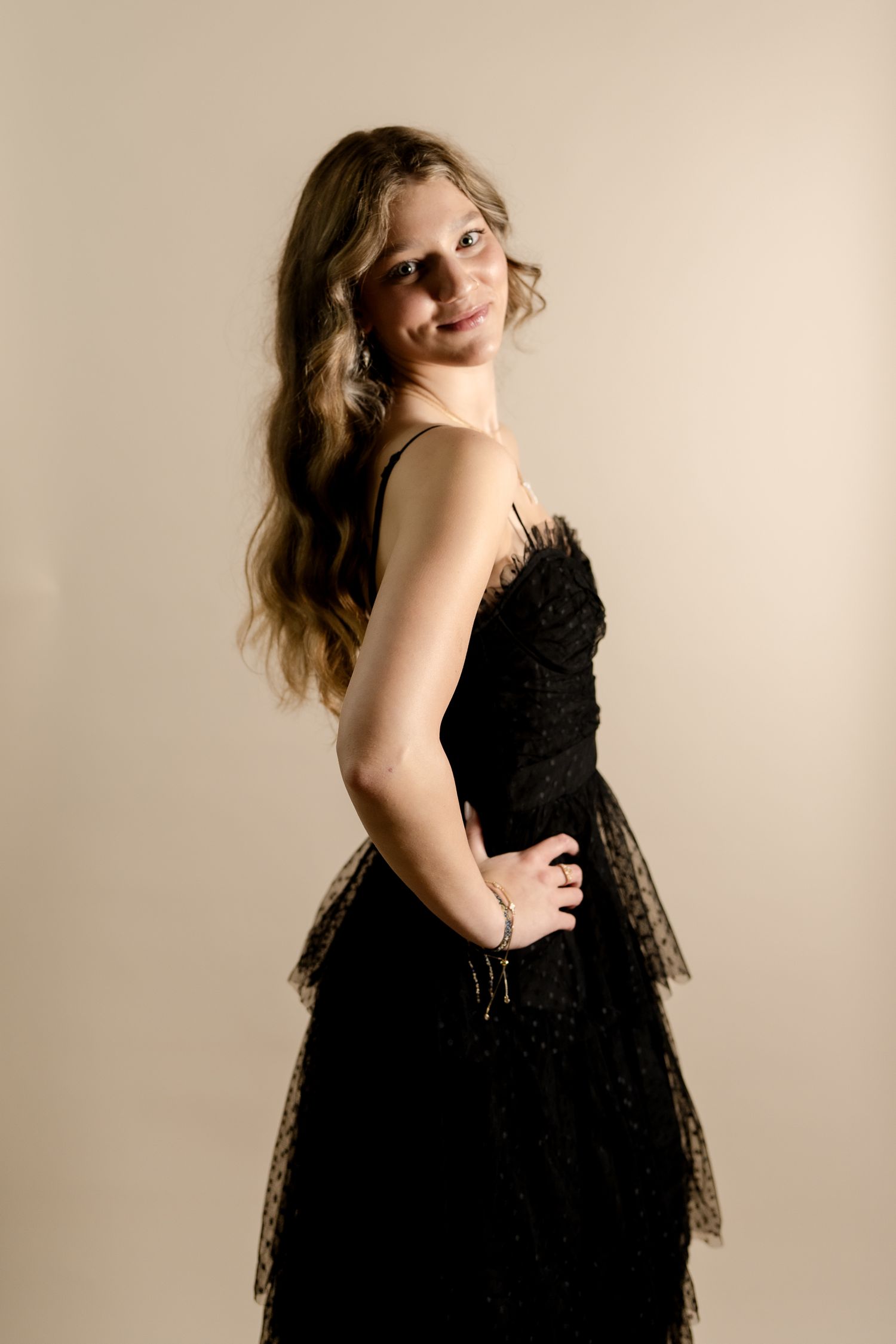 A flowing black dress is captured in a series of dramatic poses against a neutral studio background.