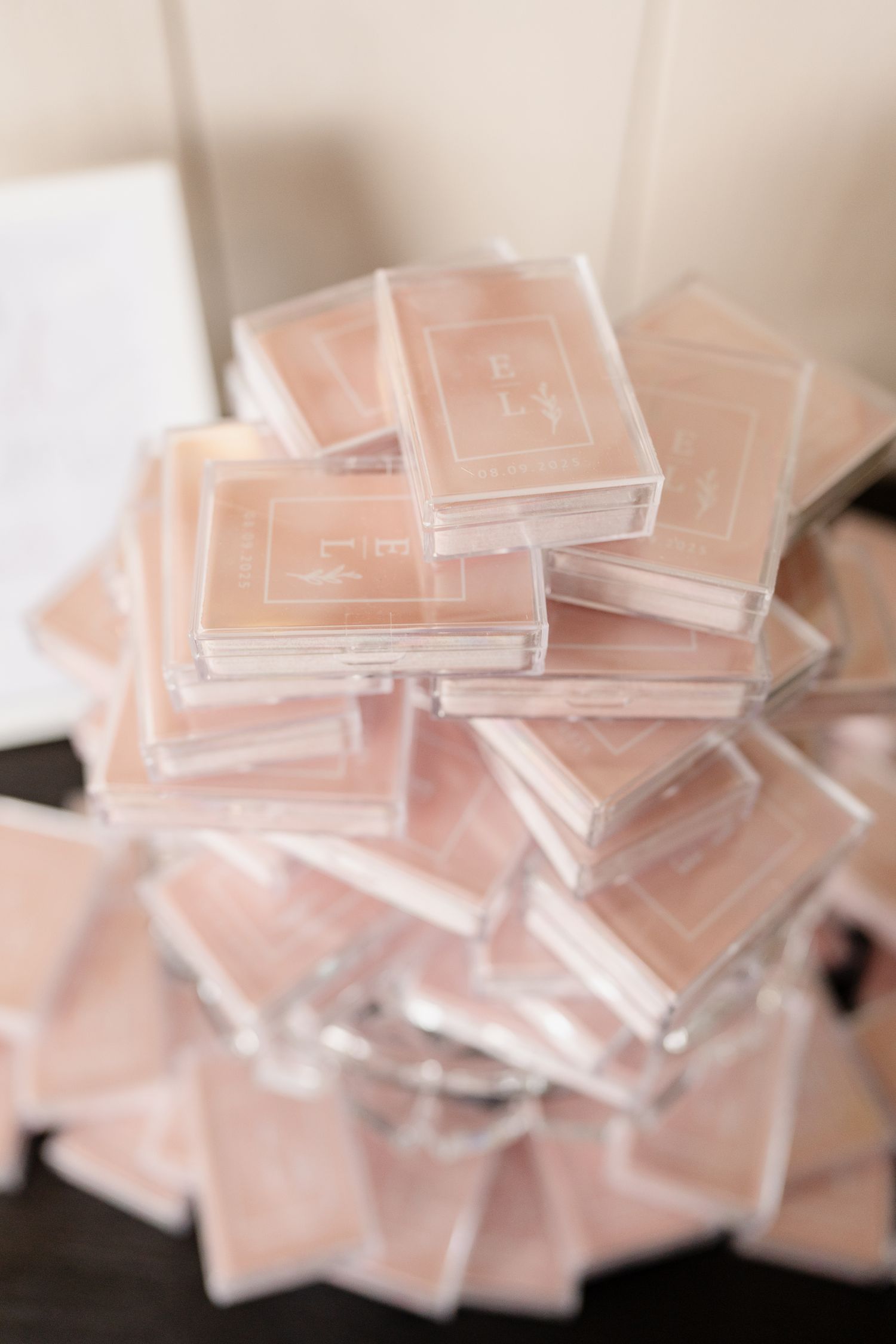 Multiple clear acrylic squares or blocks stacked together creating a geometric pattern in soft pink lighting.