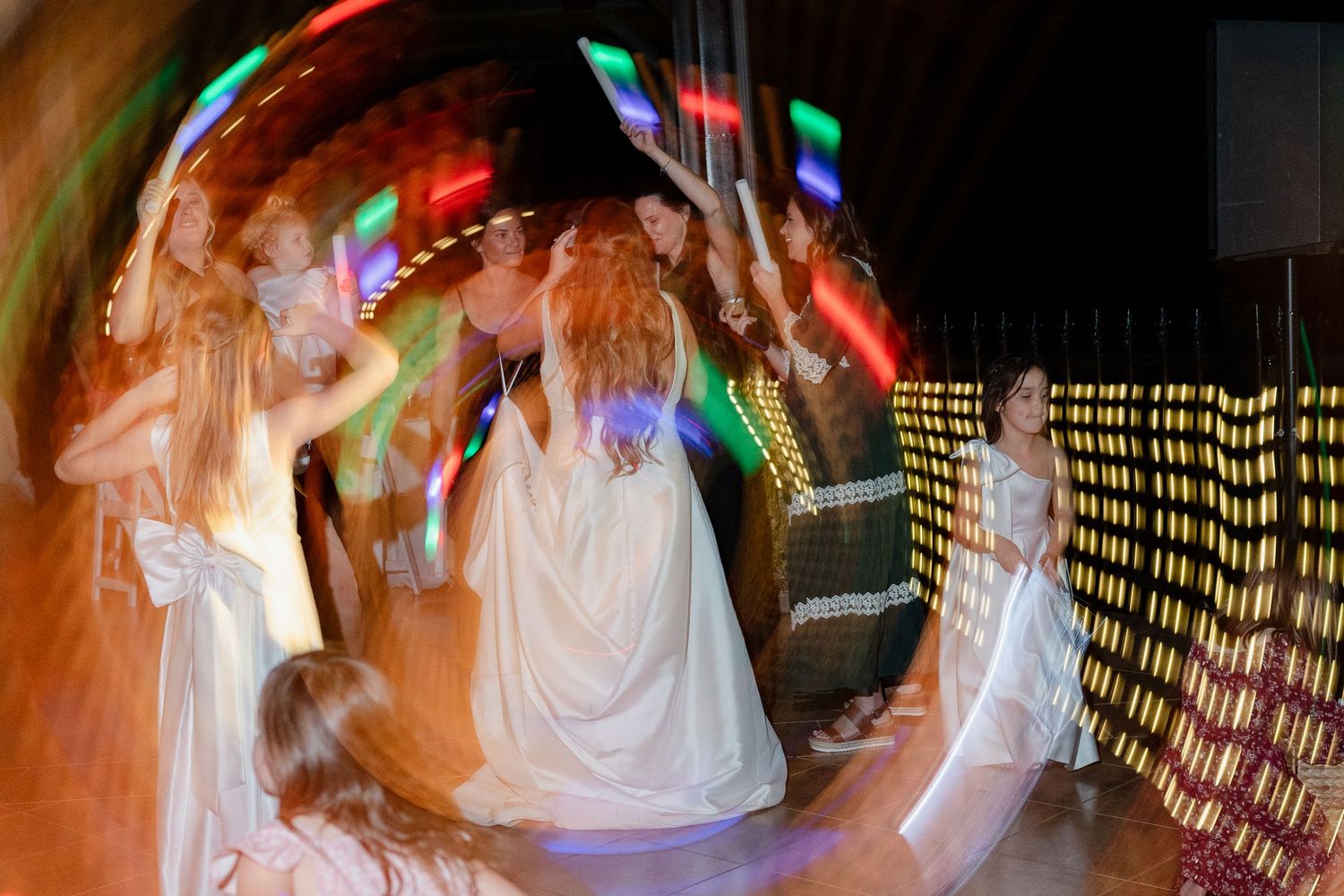 Abstract motion blur of dancing at a wedding reception with colorful lights.