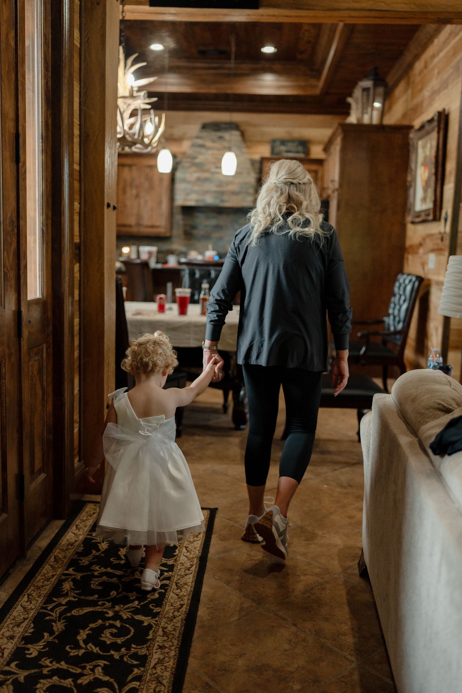 Wedding party walking through a rustic wooden venue with exposed beams and elegant decor.
