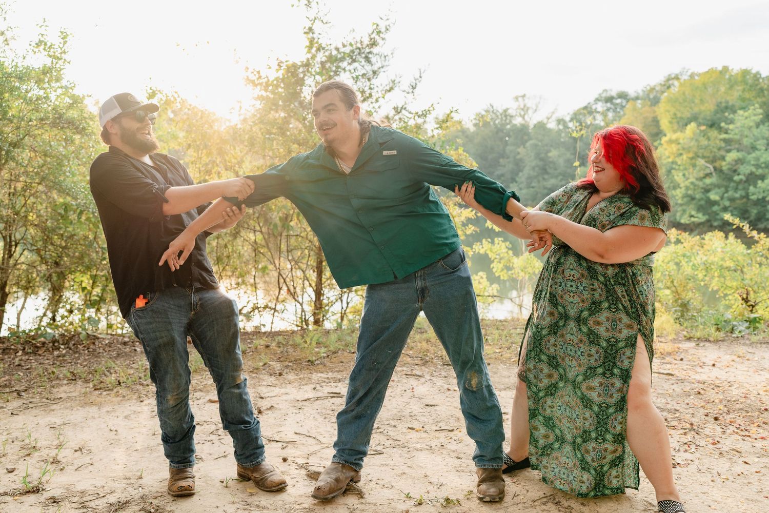 Playful candid moments captured between a couple on a sunny outdoor path.