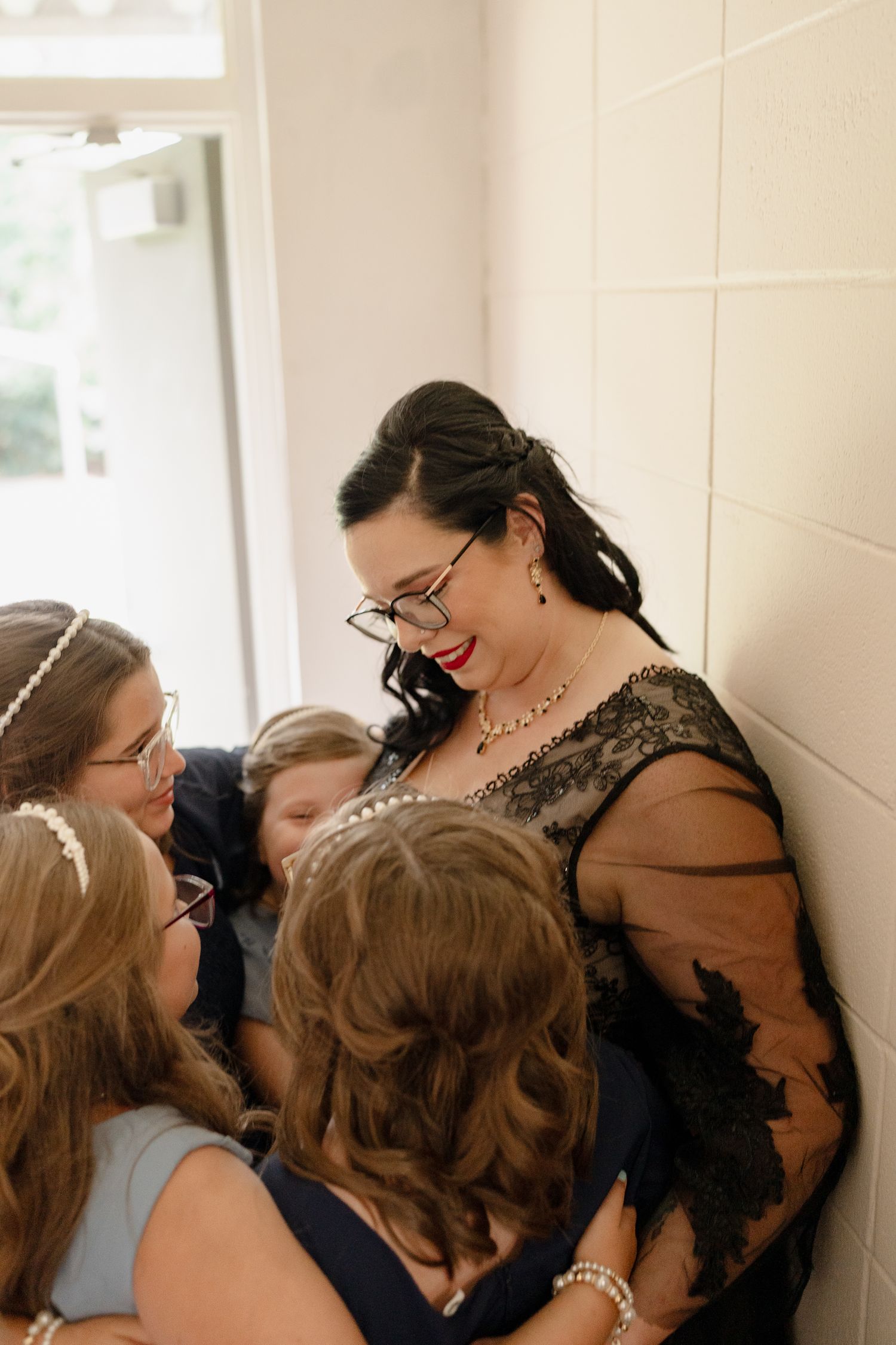 A group of people share an emotional moment together in a hallway.