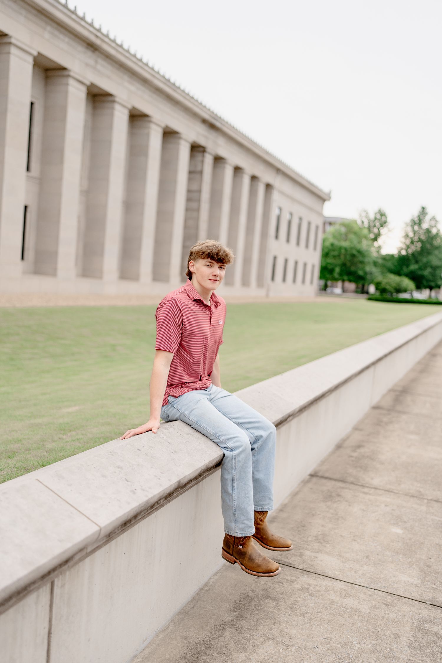 Long architectural perspective of concrete building with someone sitting on ledge.