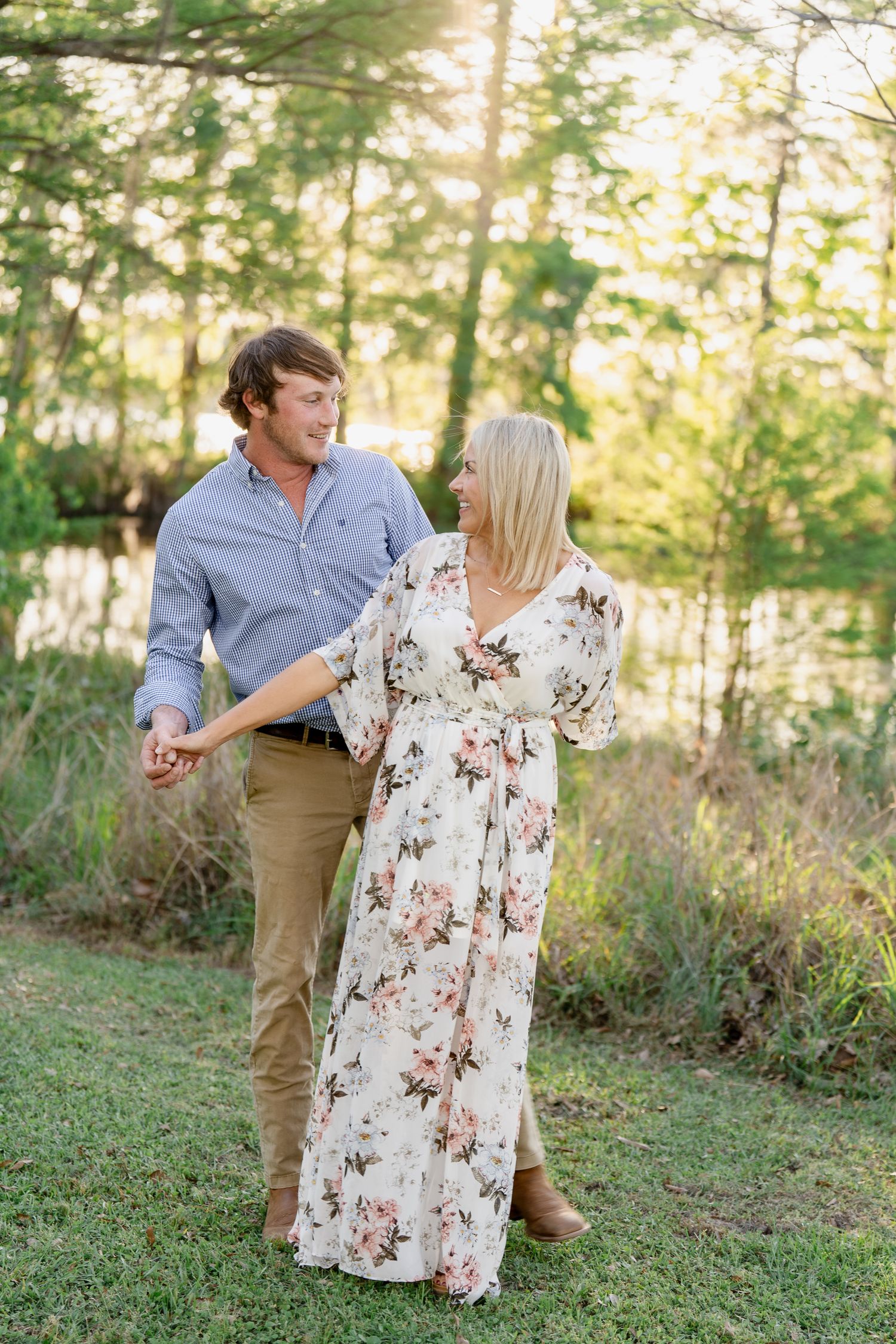 Couple in complementary outfits sharing sweet moment in wooded setting.