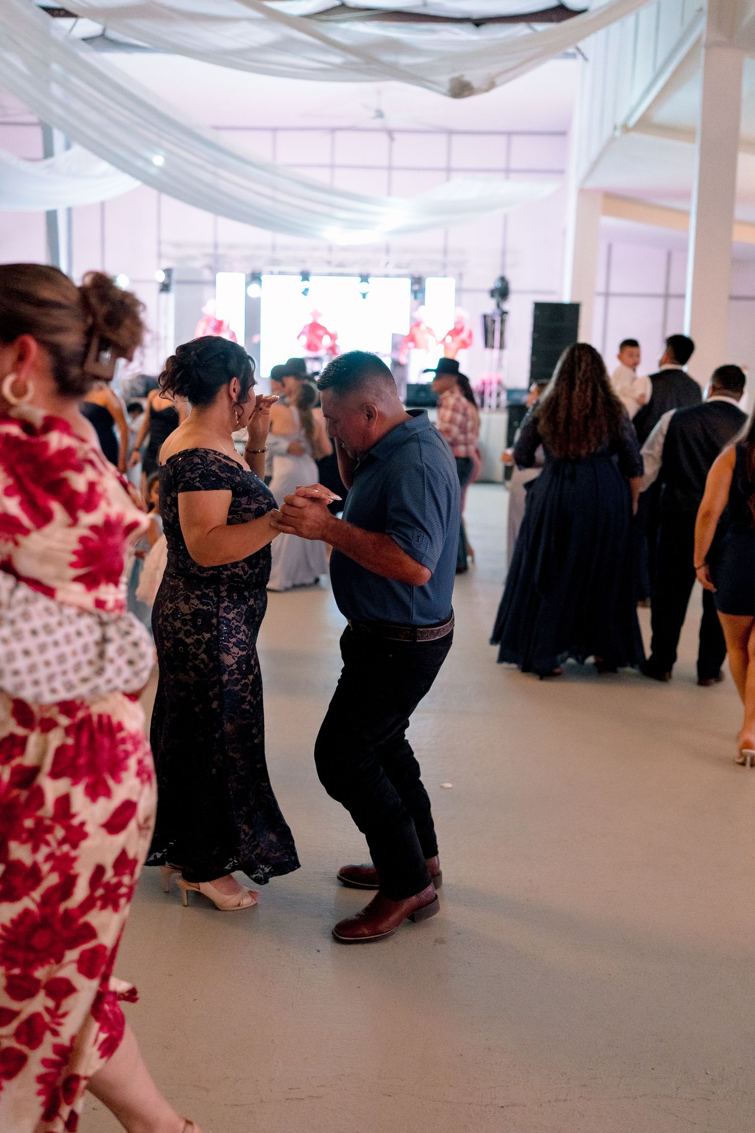 Wedding reception dance floor with guests dancing and celebrating in formal attire.