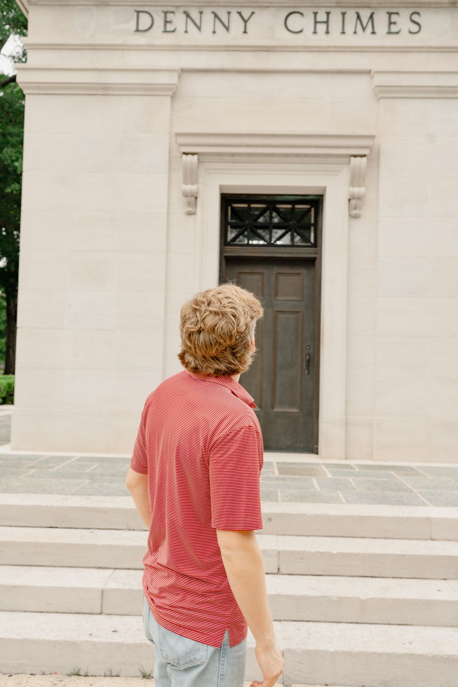 Back view of someone looking up at the entrance of Denny Chimes building.