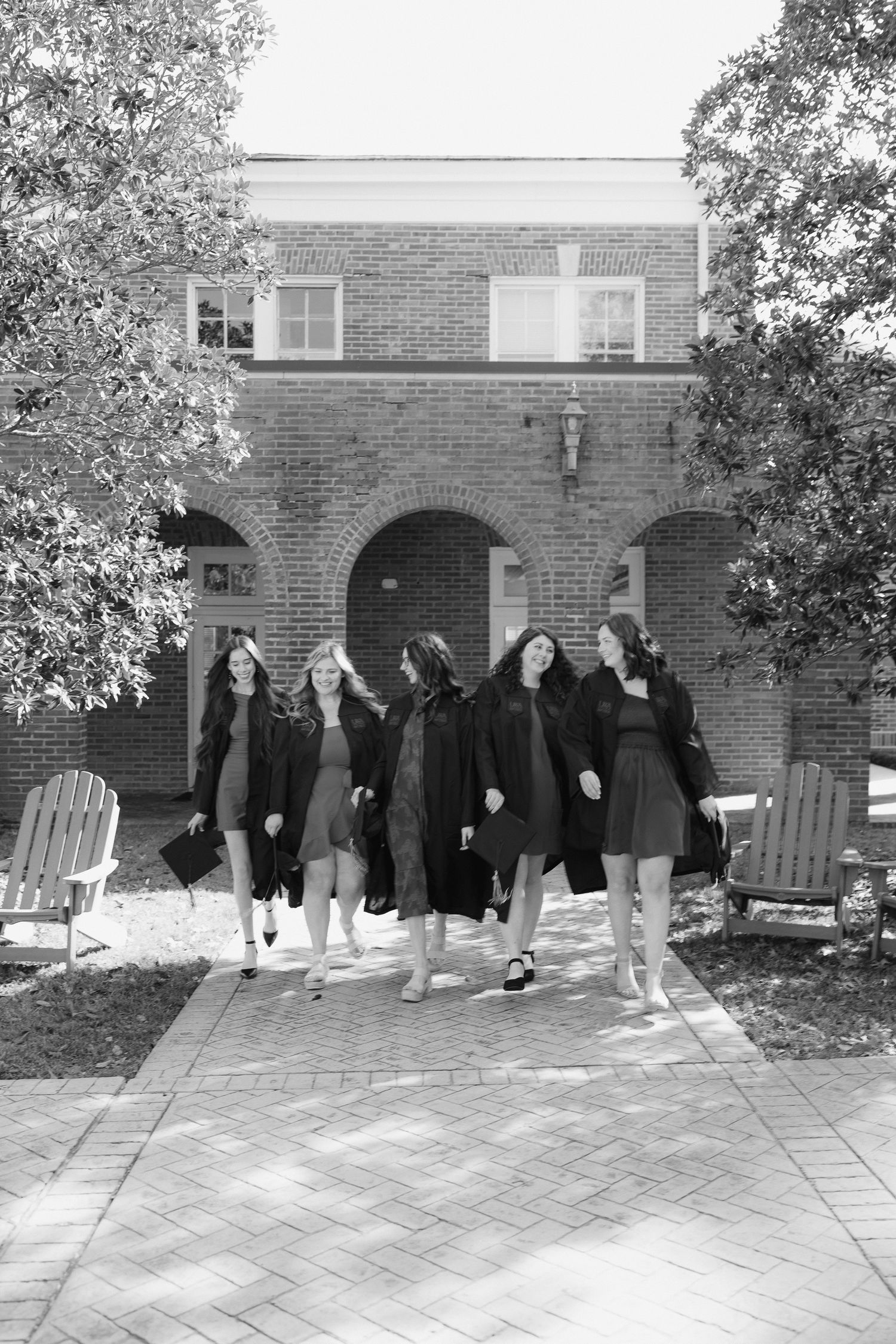 A panoramic sequence of people in dark clothing standing against a brick building exterior.