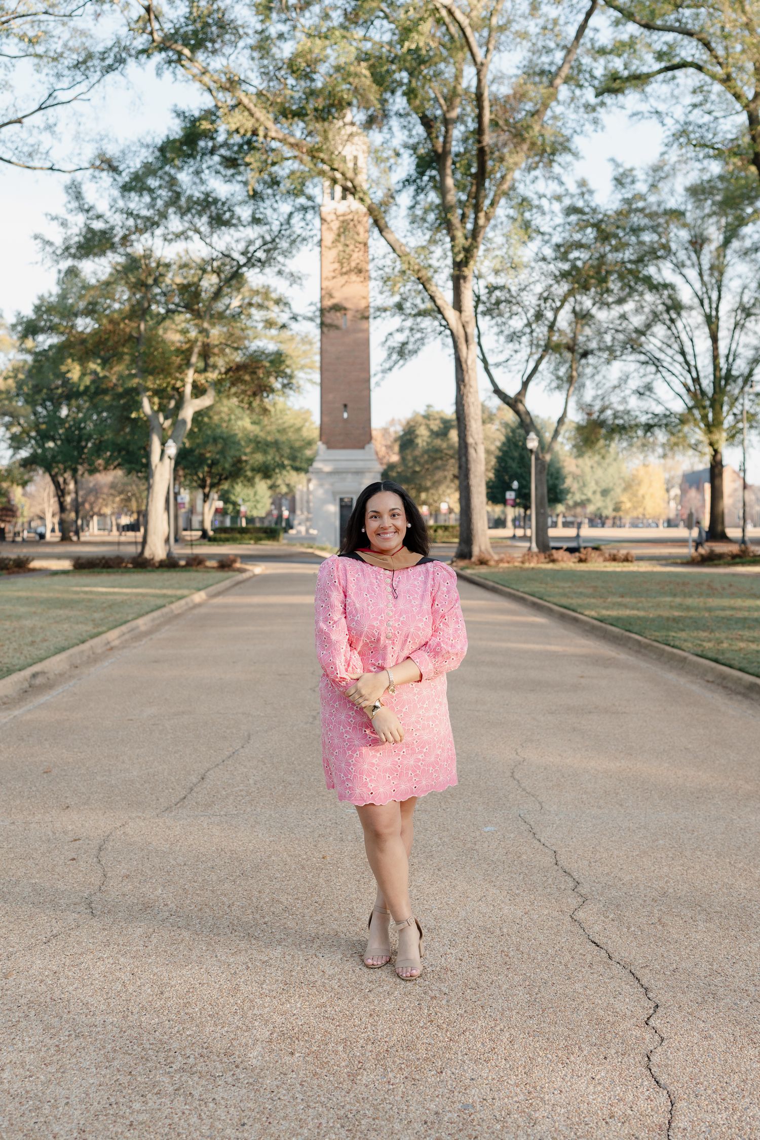 Pink dress against a university campus backdrop with a brick monument tower.