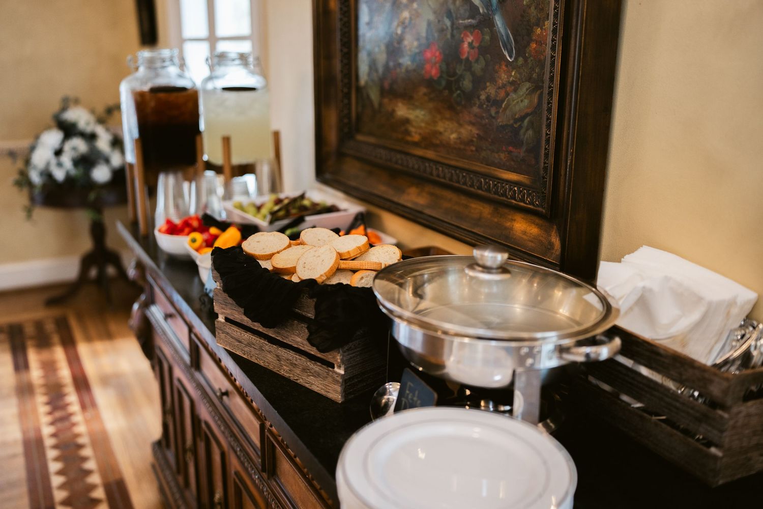 Buffet table with appetizers and serving dishes set up at wedding reception.