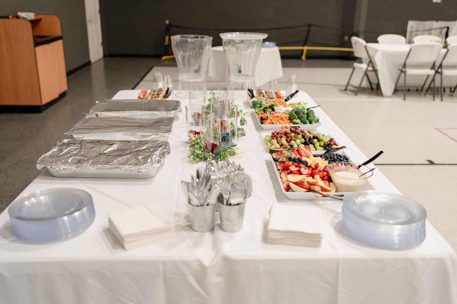 Long buffet table set up with white linens and various food platters.