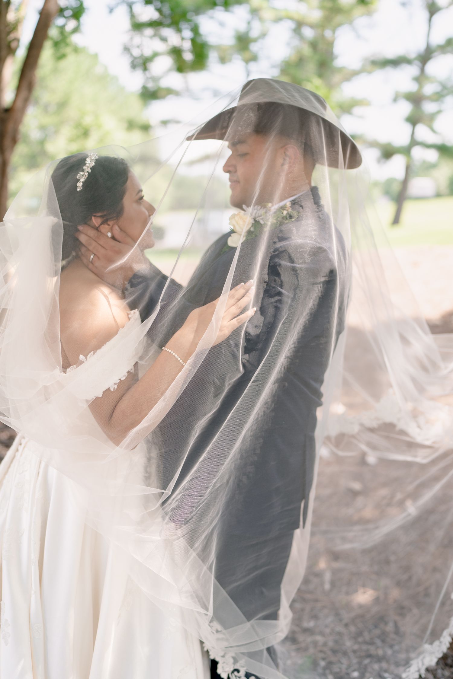 A romantic outdoor wedding photo sequence showing a couple sharing intimate moments under a flowing veil.