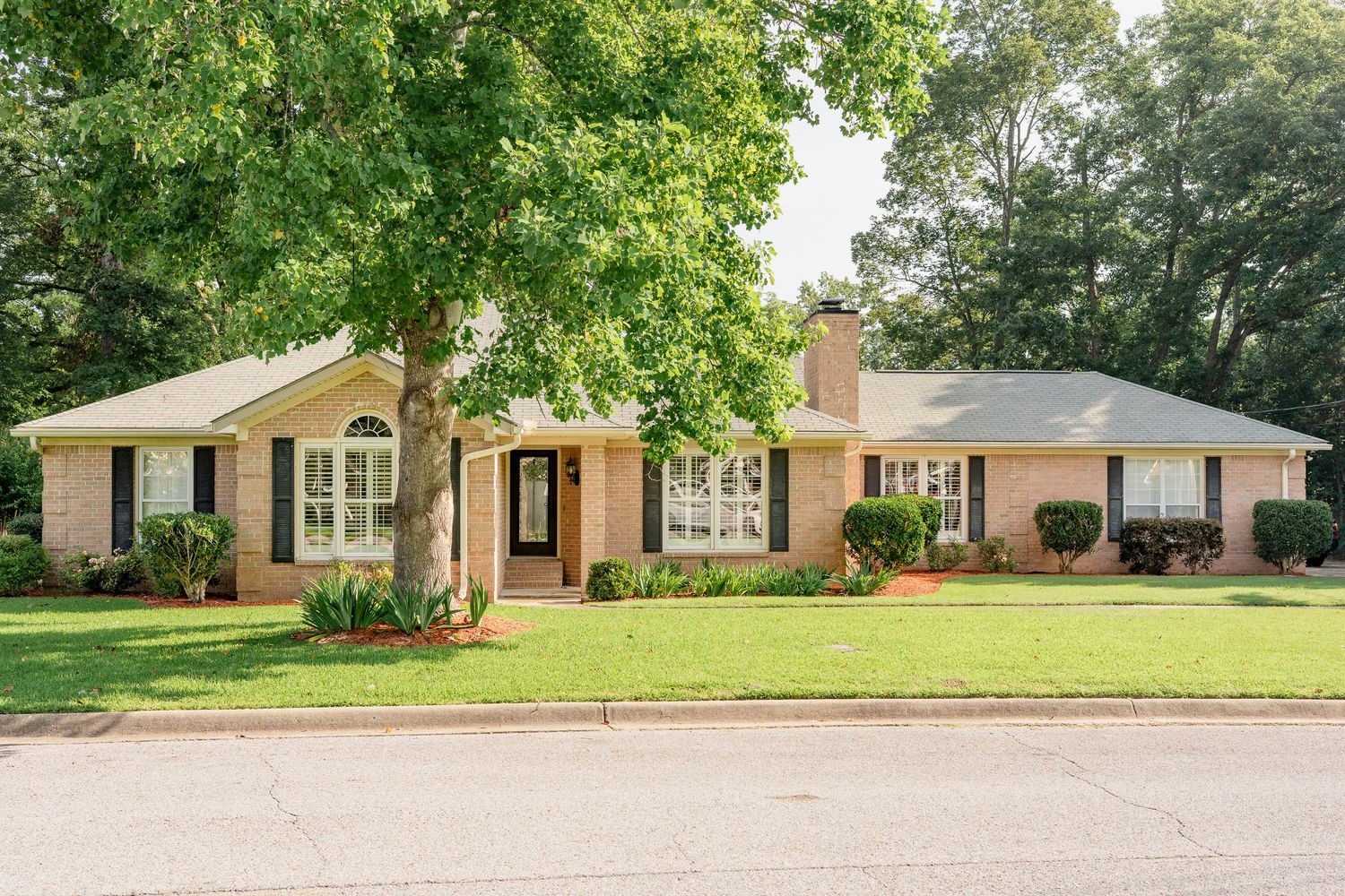 A series of six connected images showing a yellow brick ranch-style house with green lawn and mature trees.