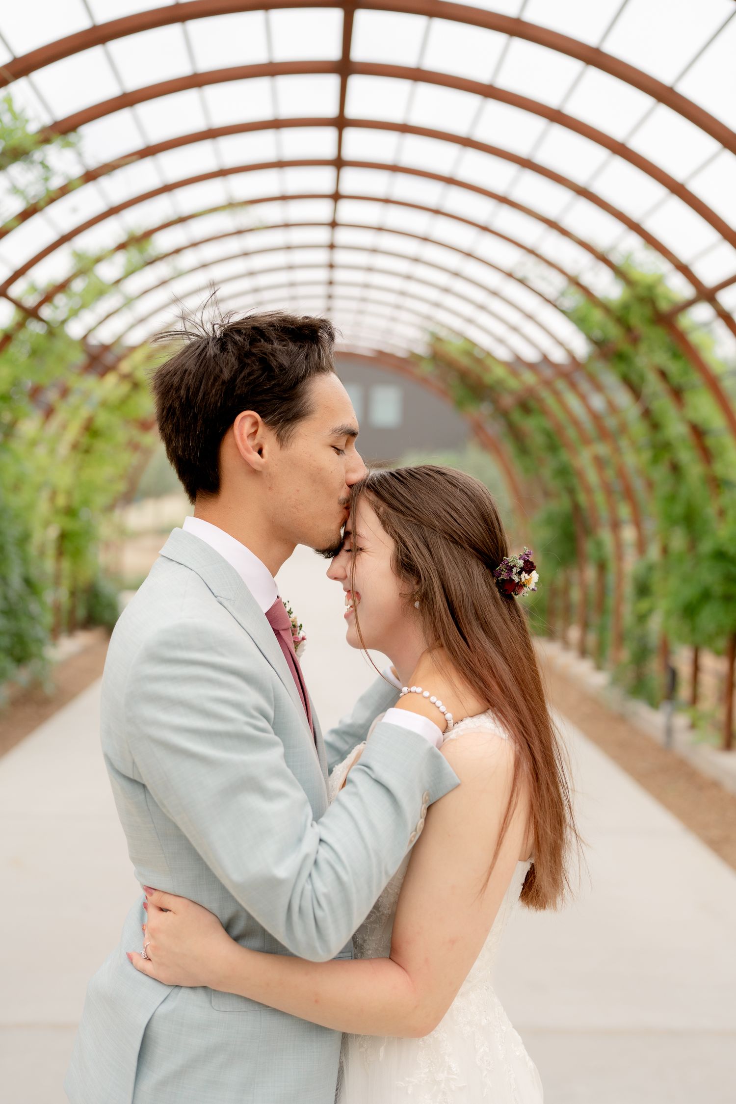Romantic greenhouse wedding photos with soft lighting and intimate moments between couple.