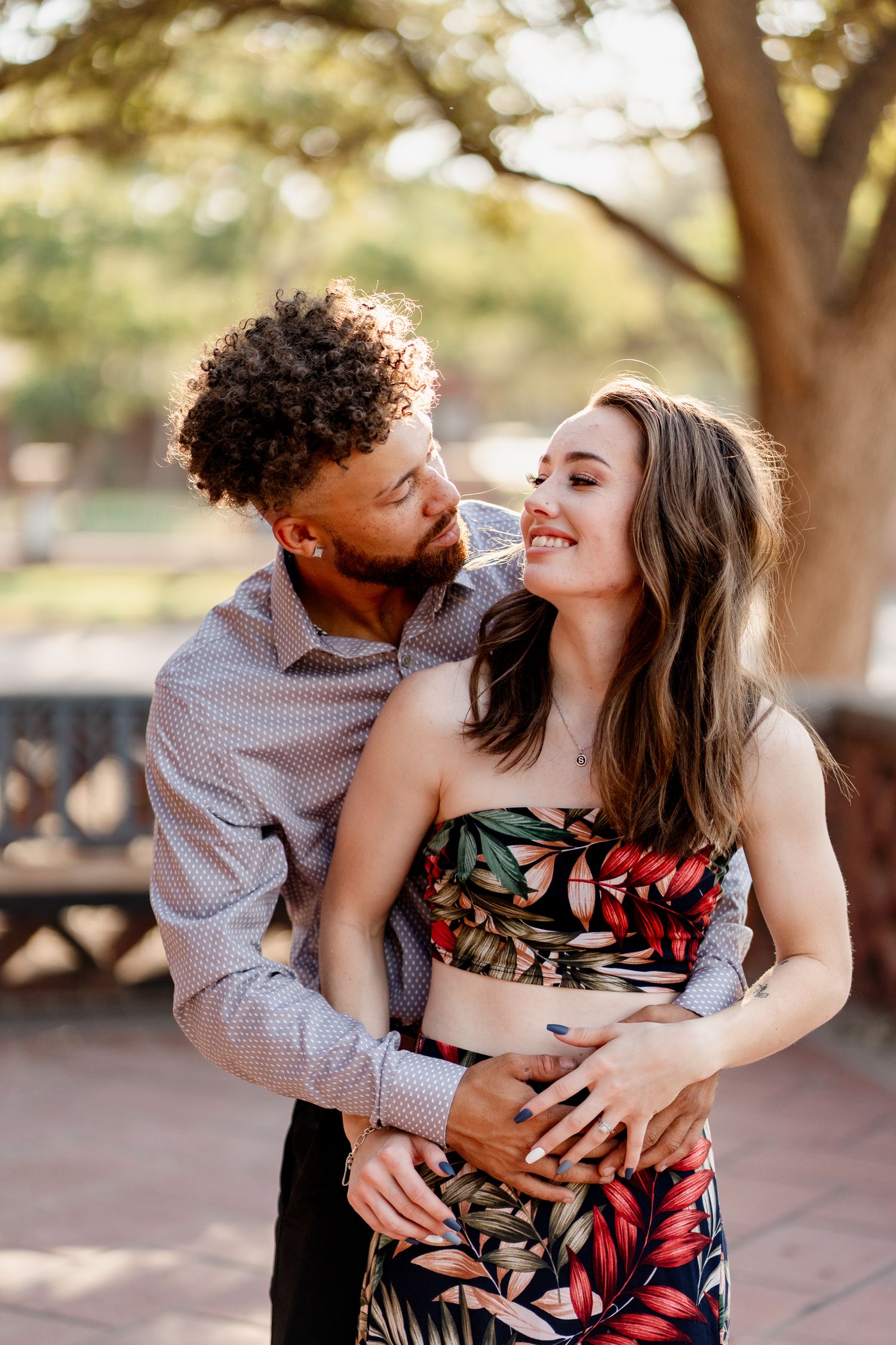 A loving couple shares playful moments during an outdoor photoshoot.