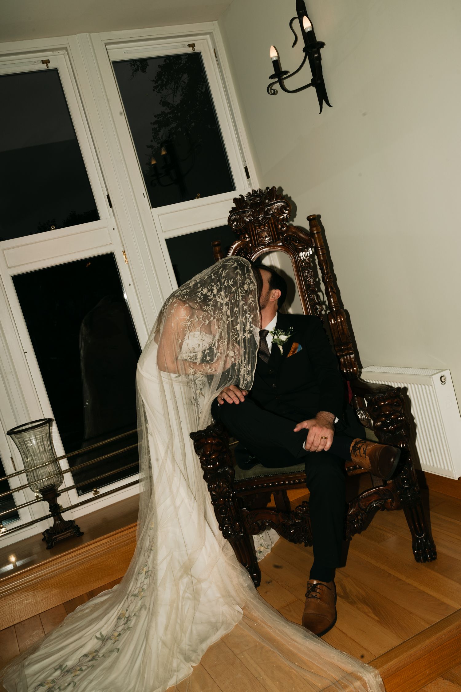 bride kissing groom while he is sitting