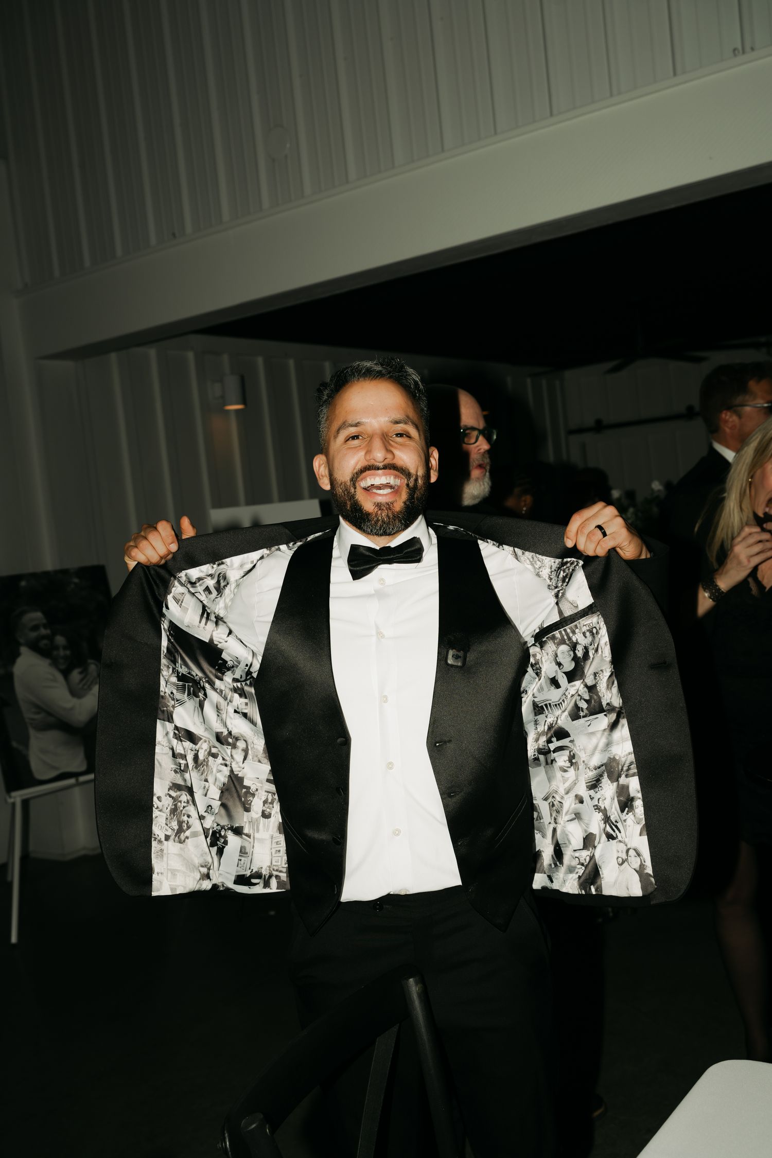 groom holding open his tux coat with images on the inside