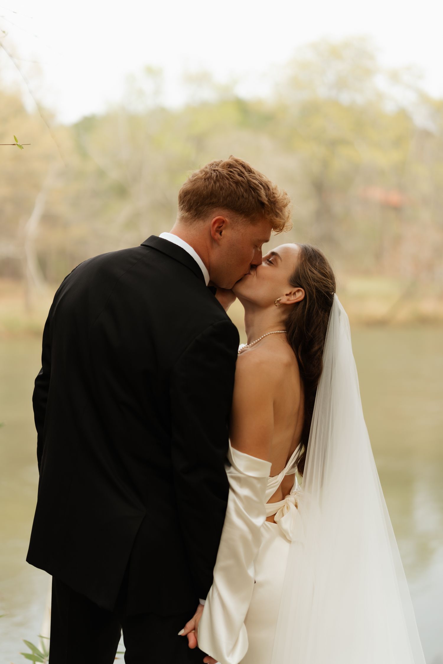 couple kissing by a river