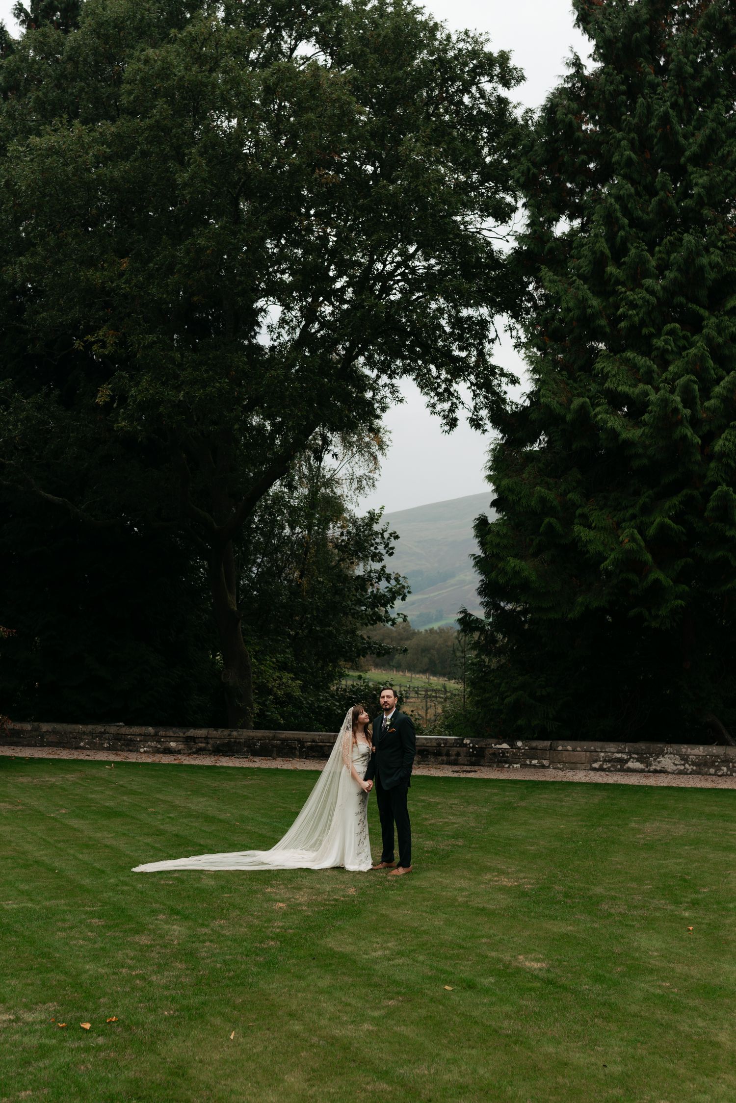 couple standing in a green grass area, holding hands
