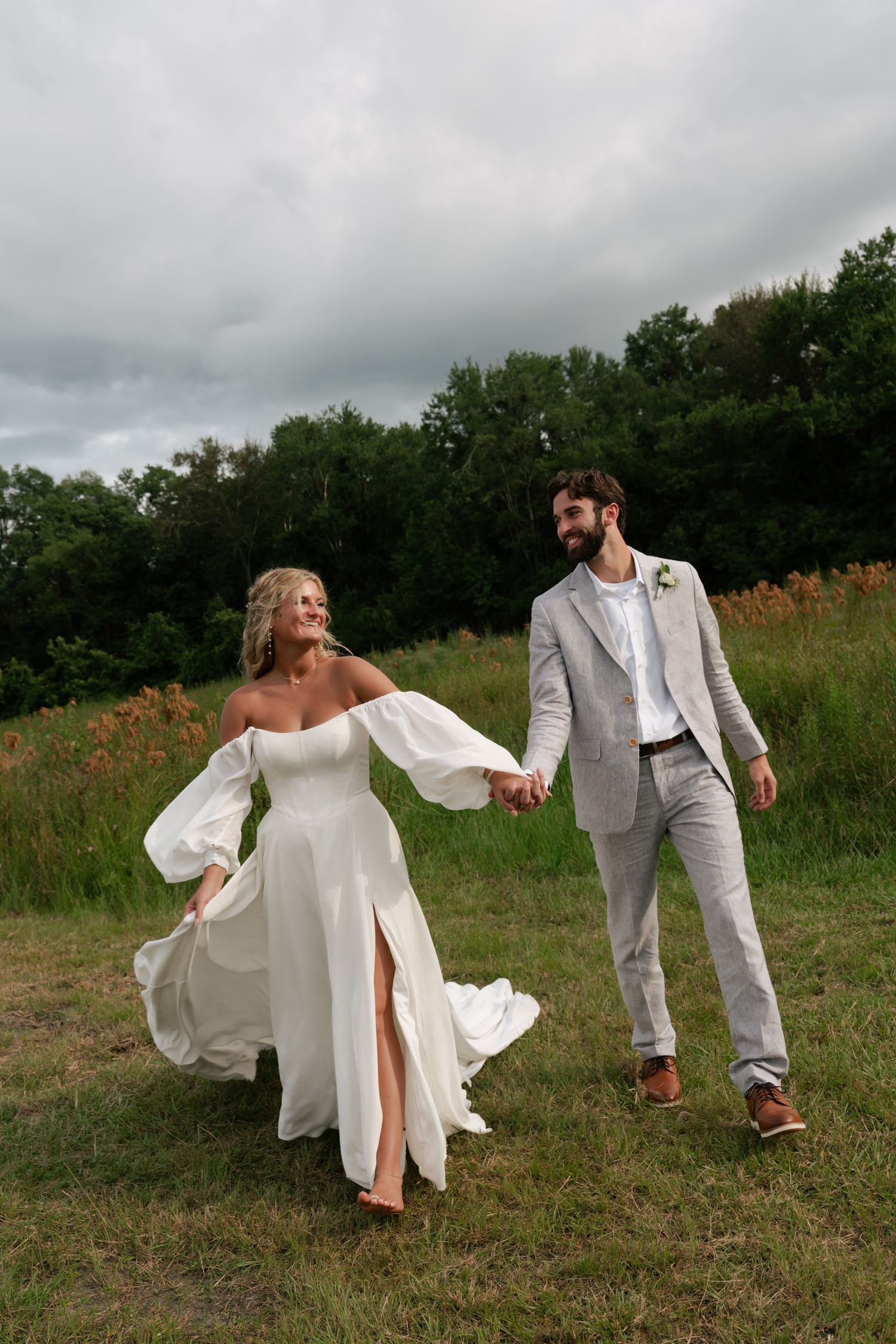bride and groom holding hands, and walking towards camera