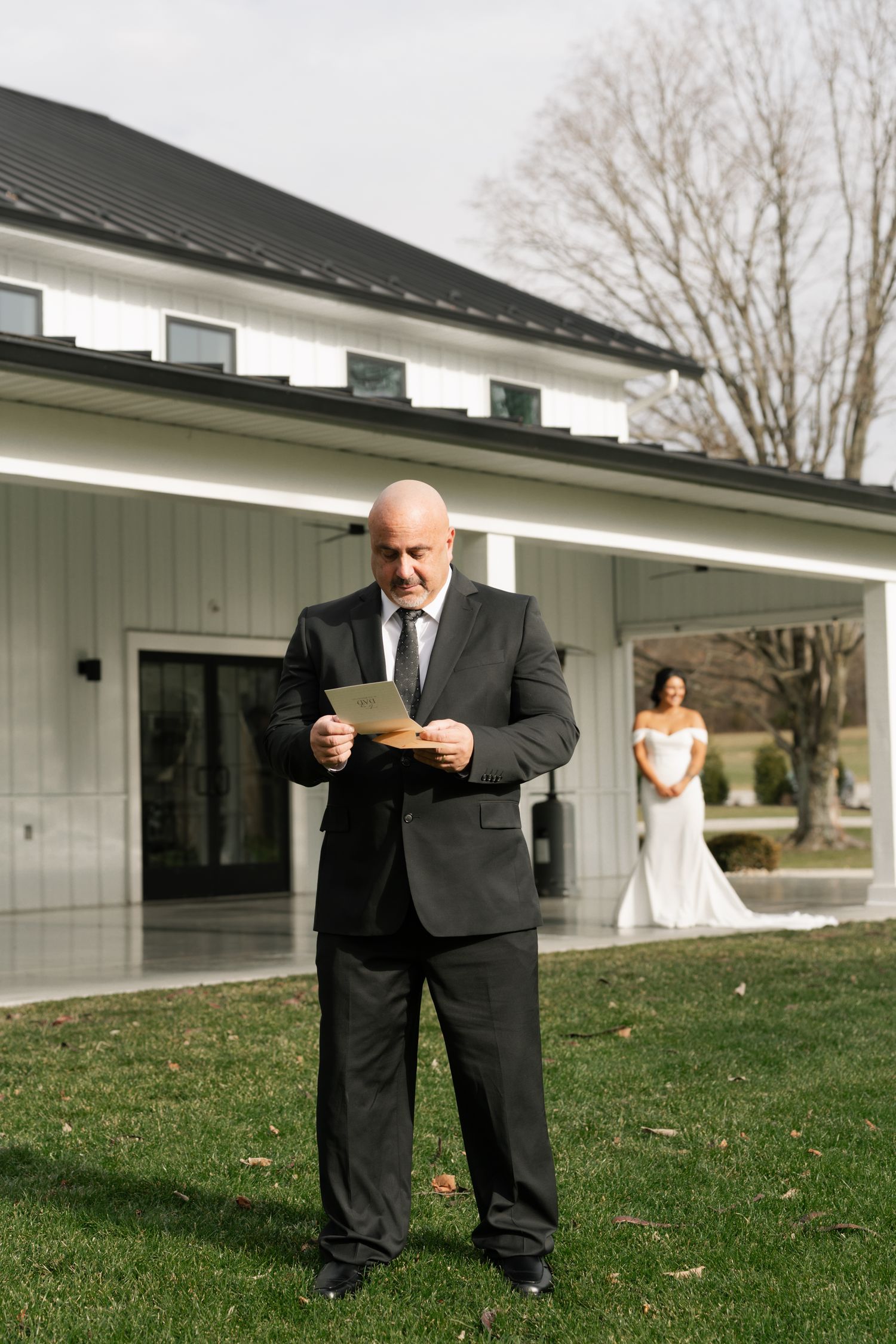 father reading letter from daughter, she is in the background in her wedding dress