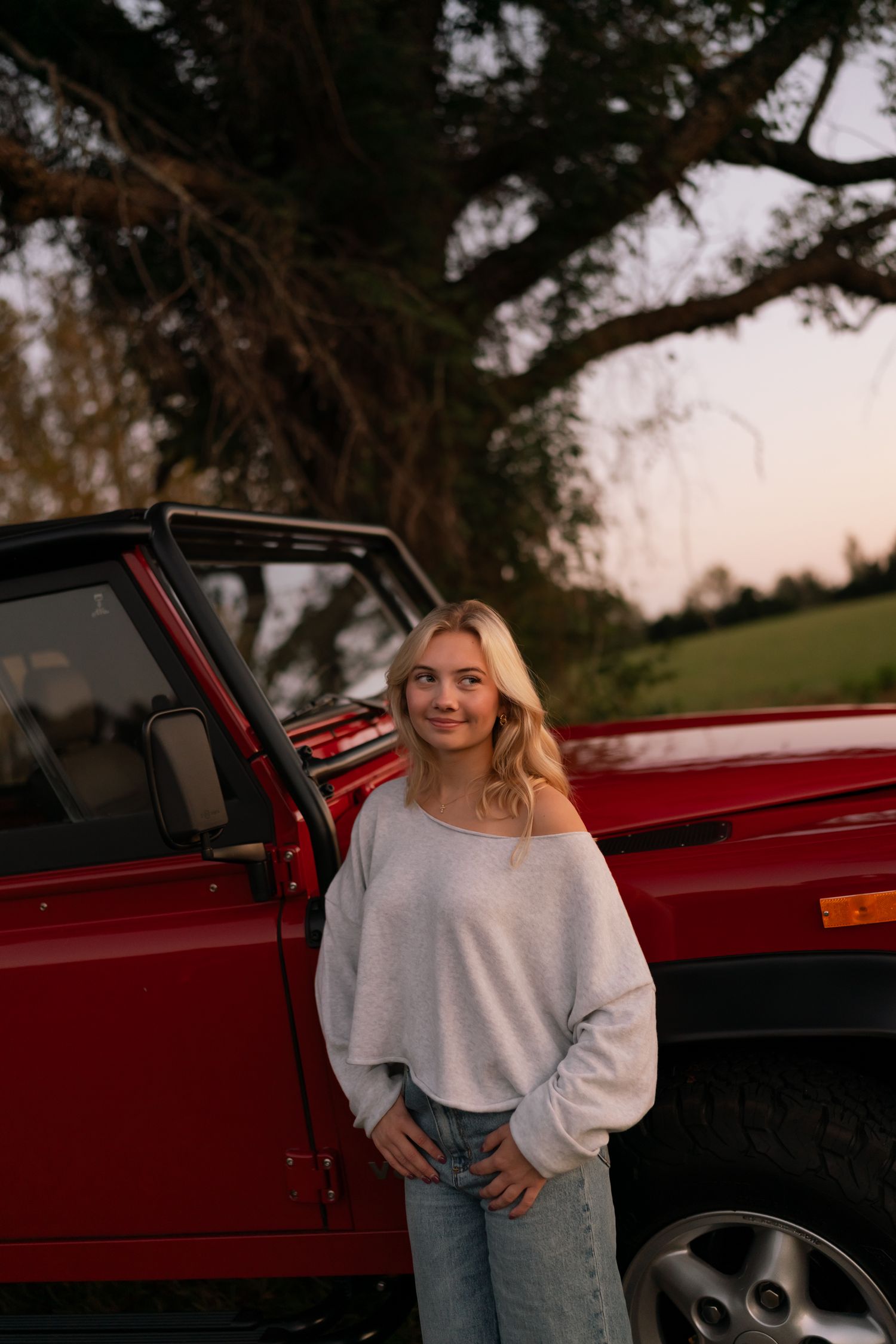 girl smiling standing in front of a car, in a field in Georgia