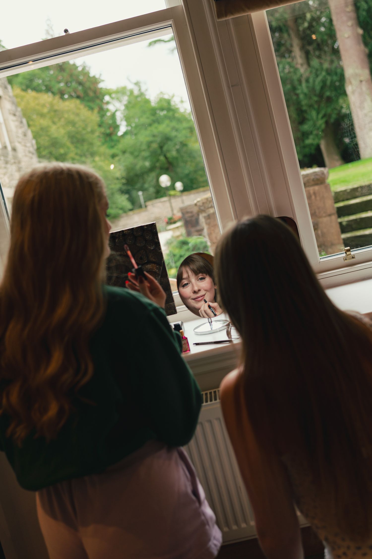 bride and friend getting ready for wedding, putting on makeup